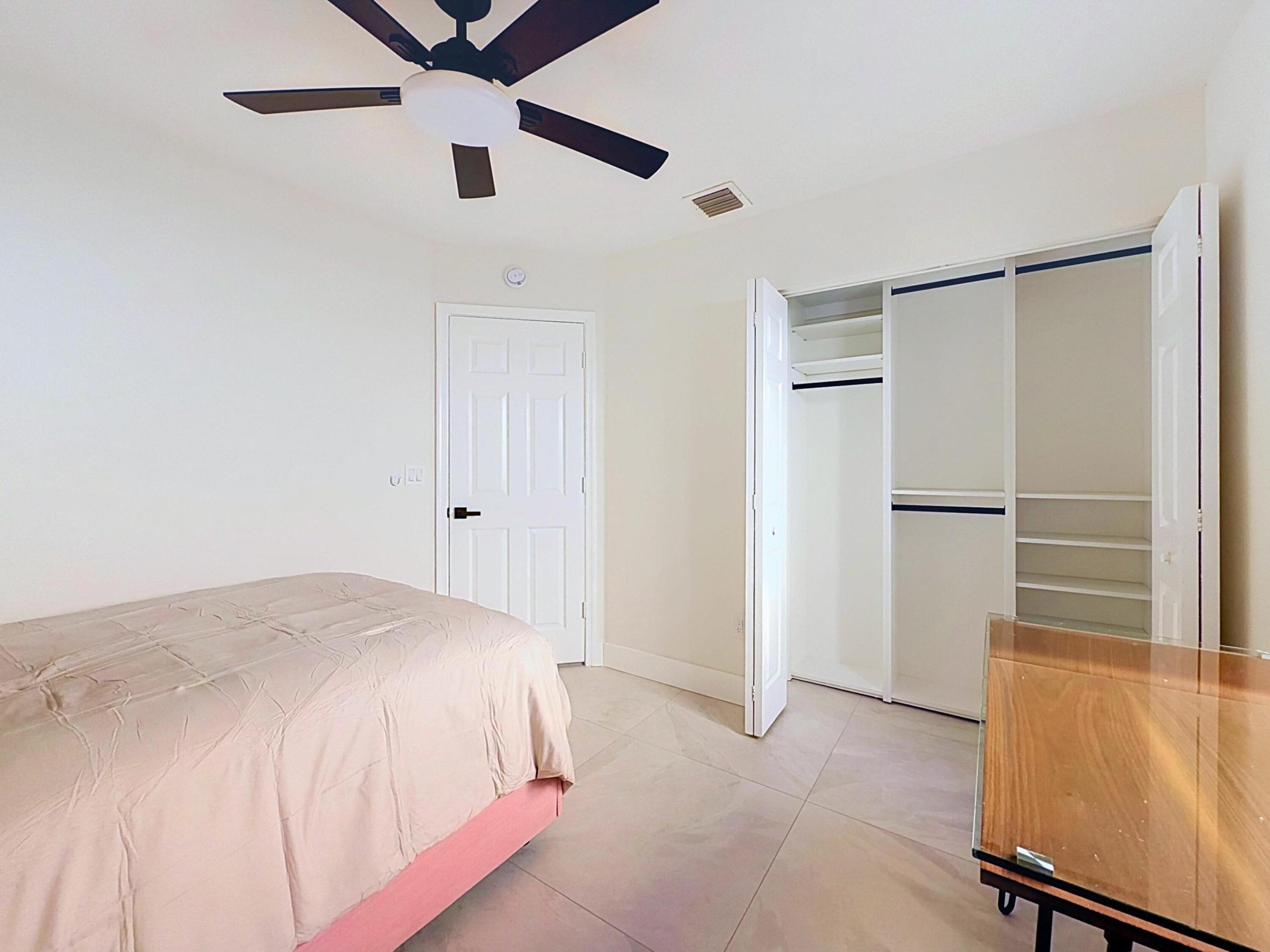 Spacious bedroom with built in California Closet style organizers.