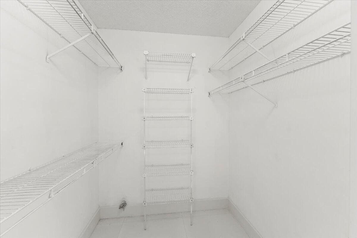 The third bedroom features a small walk-in closet with wire shelves.
