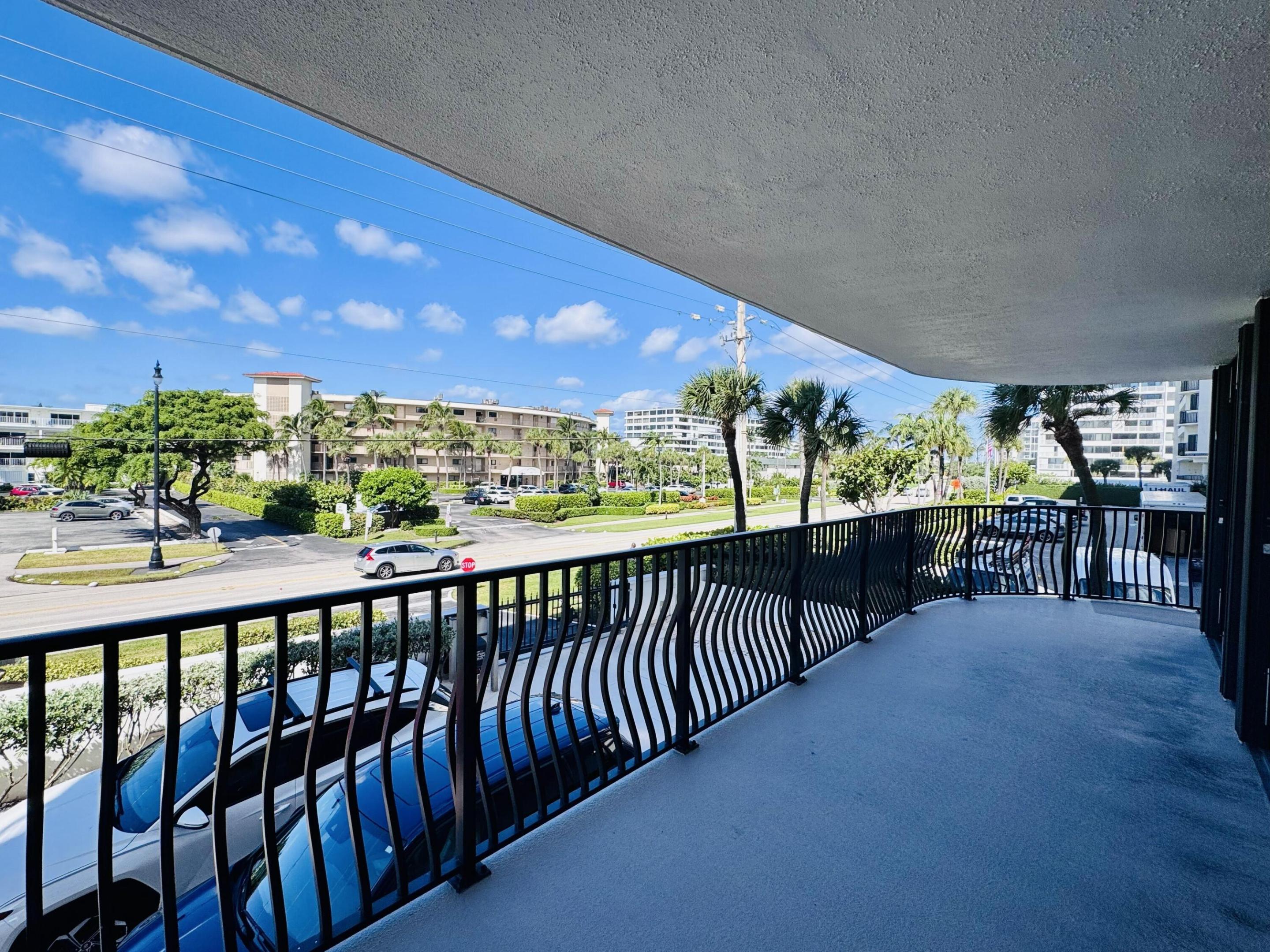 Covered balcony featuring concrete flooring and a decorative metal railing