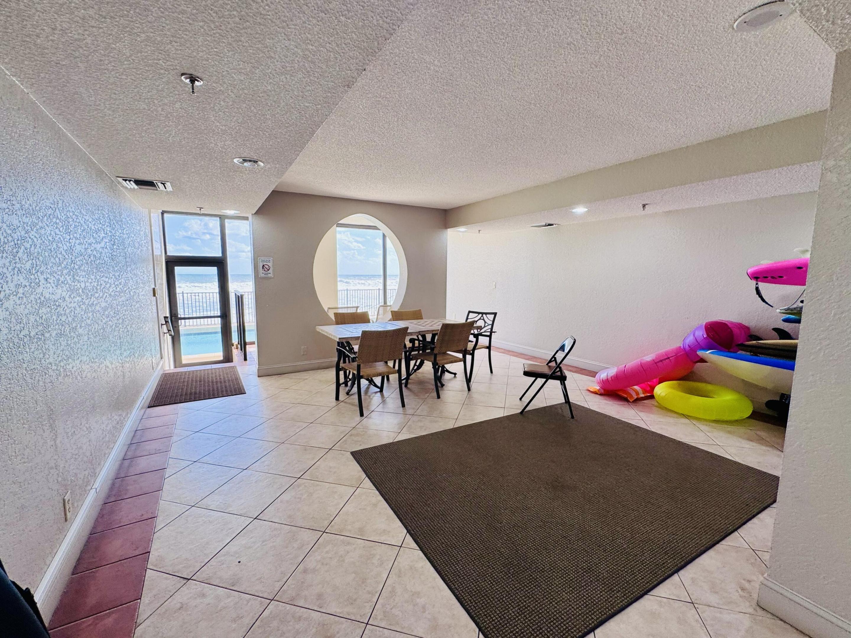 Open-concept room with tile flooring, recessed lighting, and a prominent circular architectural window featuring water scenery