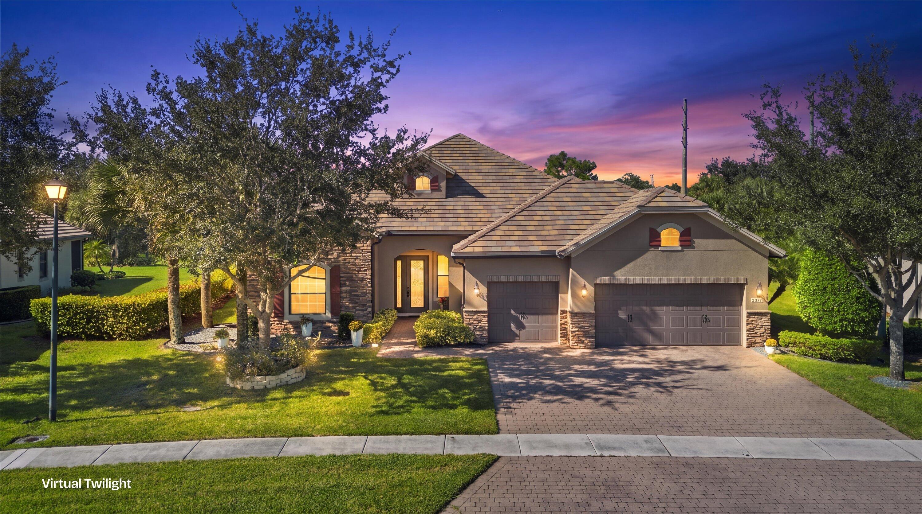 Multi-gabled exterior featuring stone veneer siding, a paved driveway, and a three-car garage Multi-gabled exterior featuring stone veneer siding, a paved driveway, and a three-car garage