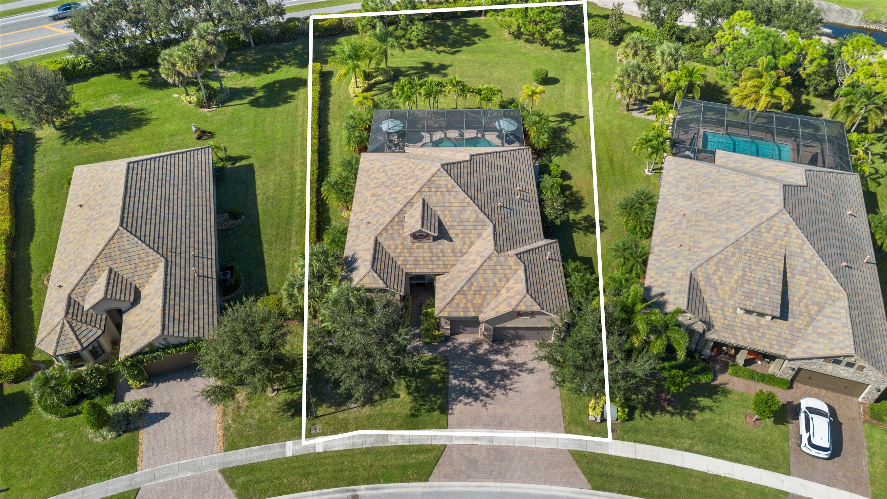 Aerial perspective featuring a paved driveway, a multi-gabled roof, an enclosed screened-in pool, and extensive lawn landscaping