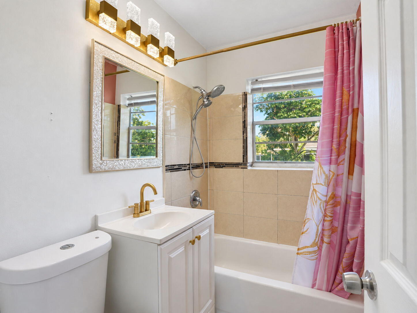 Bathroom featuring gold accents and handheld shower head
