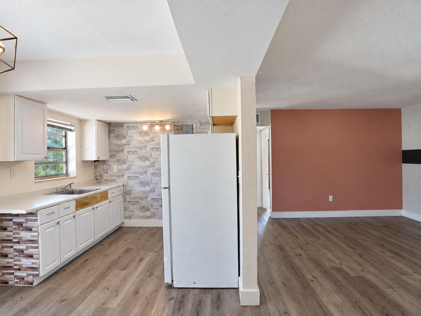 Kitchen featuring white shaker-style cabinetry, and wood-finish flooring