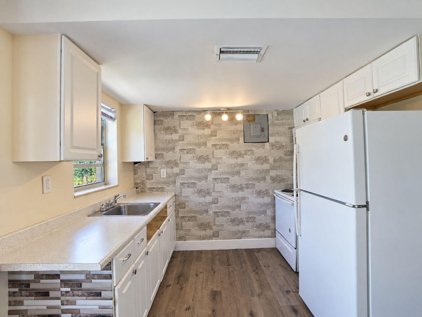 Kitchen featuring white cabinetry, wood-finish flooring,