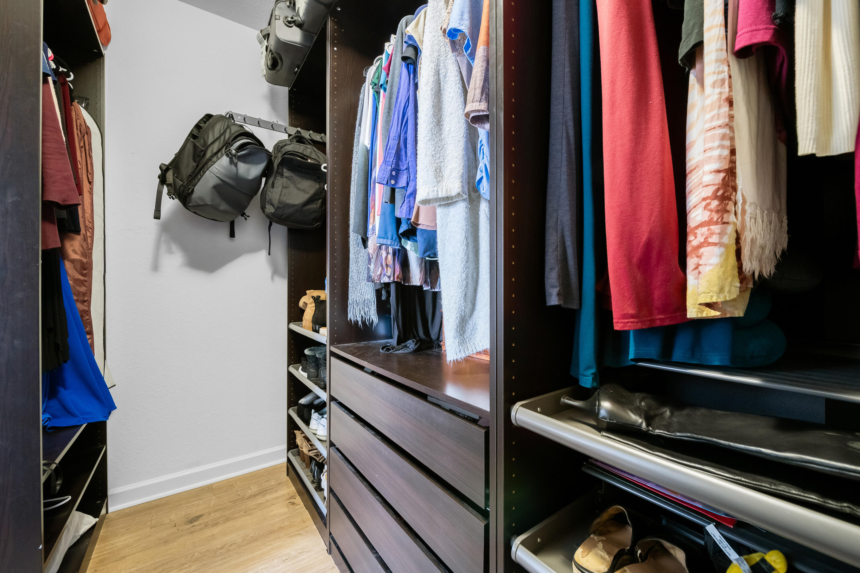 Beautifully customized primary walk-in closet featuring thoughtfully designed built-ins, abundant storage and all the bells and whistles for effortless organization and everyday luxury.