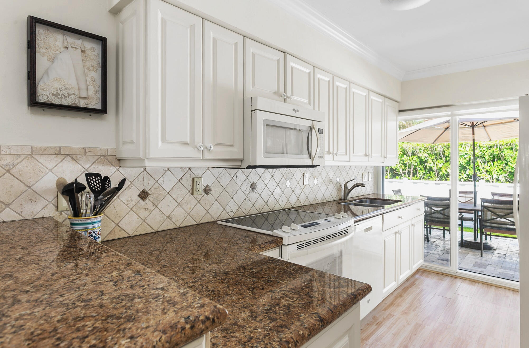 Light filled kitchen featuring sliding glass doors to outside patio and entertainment area