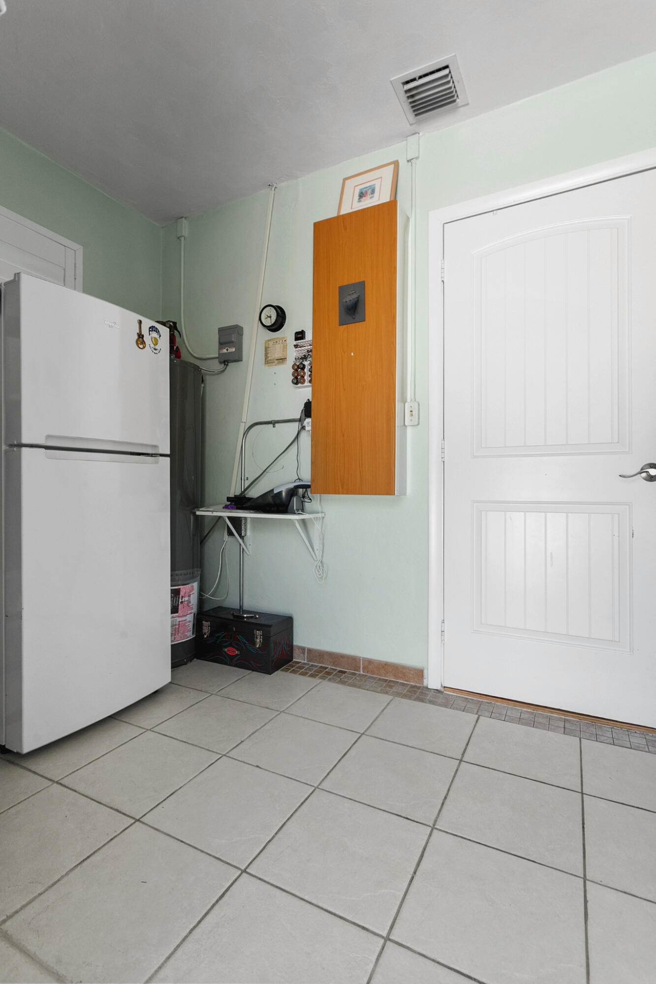 Utility area featuring washer, dryer, shelving, extra refrigerator and plenty of space for pantry items, ironing board, vaccum cleaner, etc