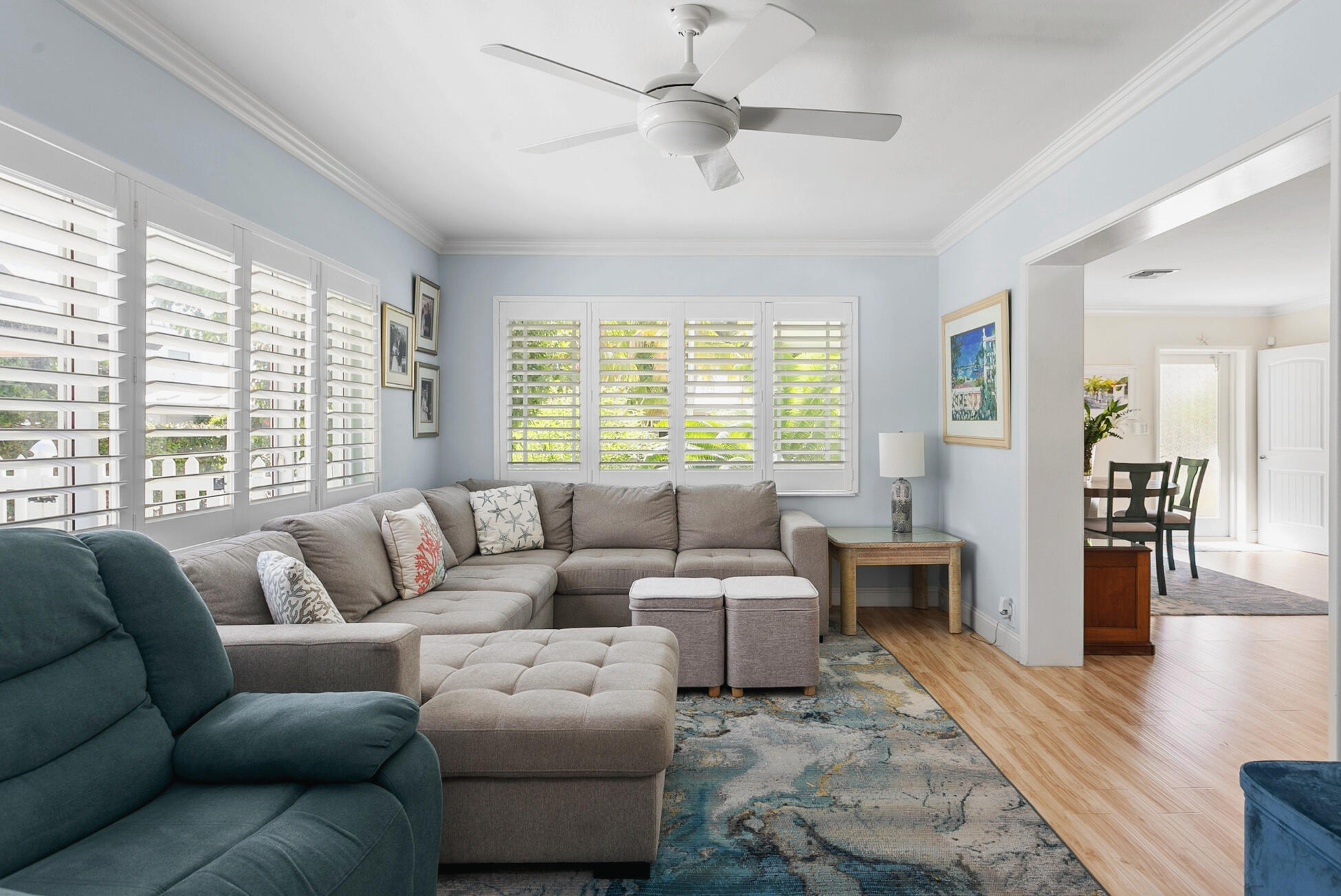 Spacious Living area featuring plantation shutters, crown molding, and wood-finish flooring