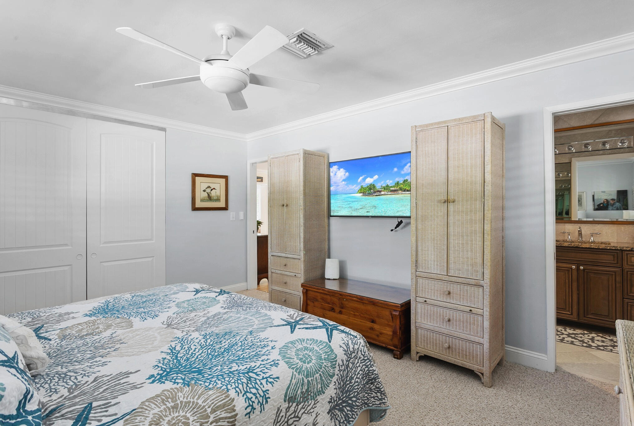 Neutral interior featuring crown molding, a ceiling fan, and double-door closet cabinetry
