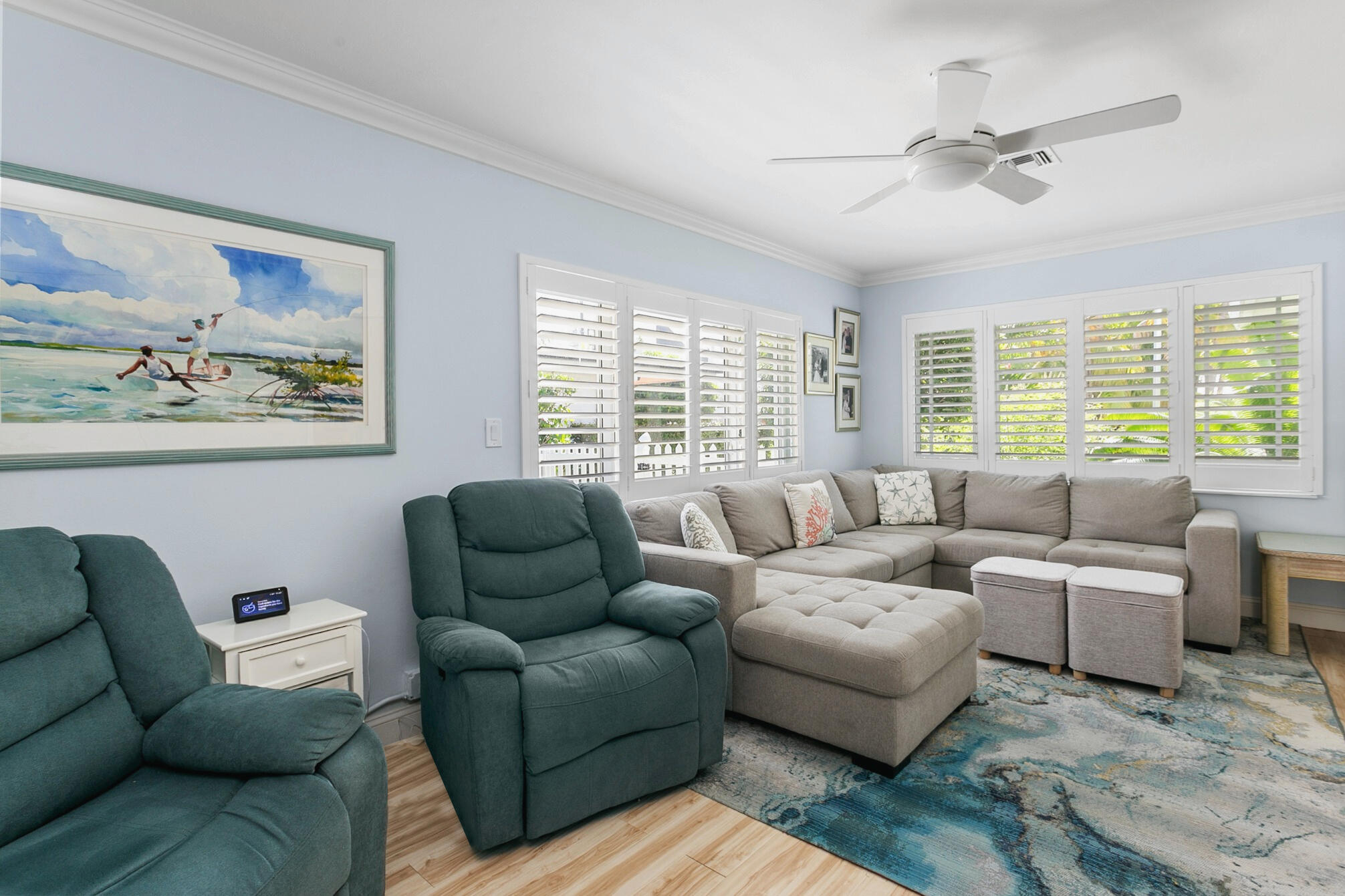 Bright interior featuring crown molding, multi-panel plantation shutters, and a central ceiling fan