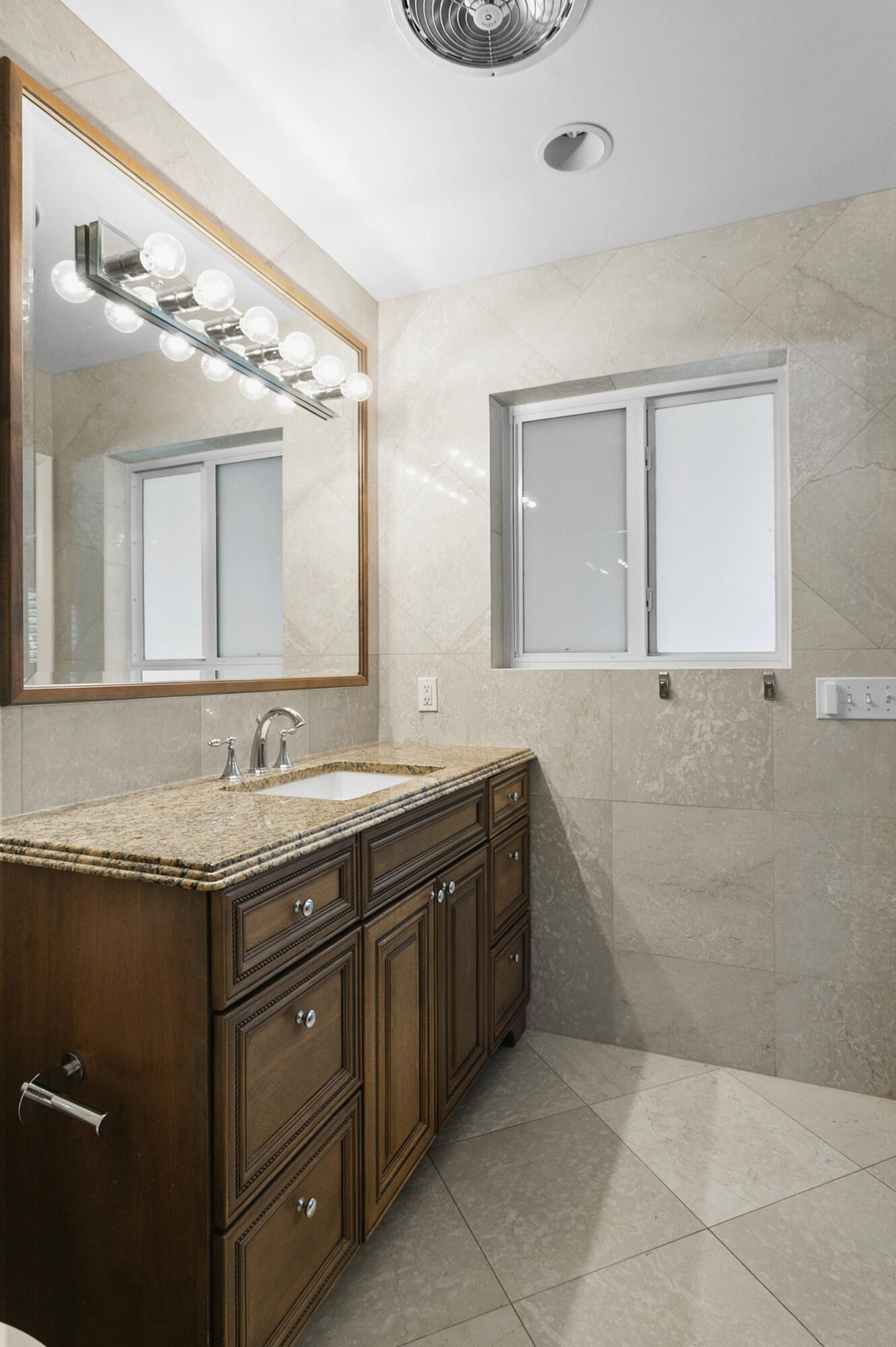Master bathroom with Custom wood cabinetry with stone countertop, undermount sink and large walk in shower