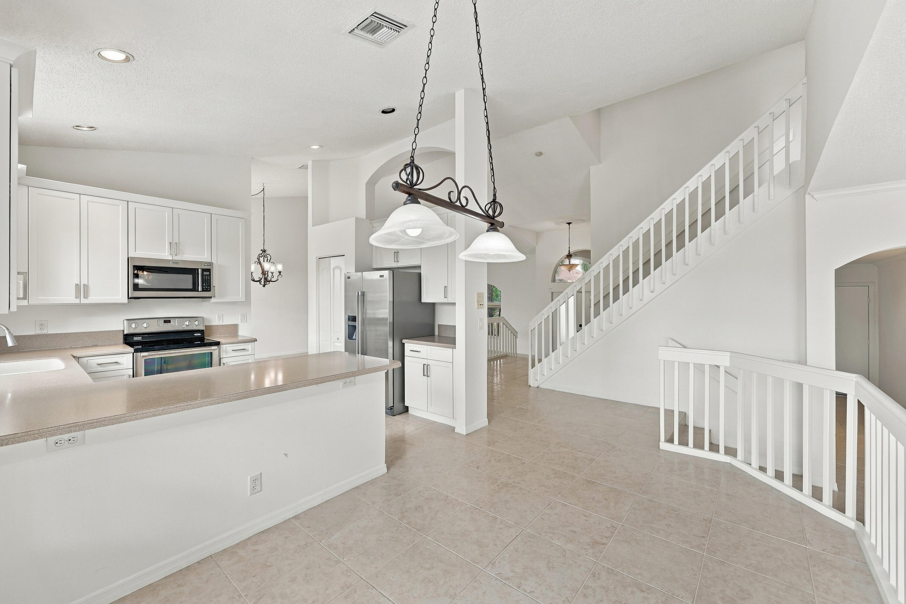 An inviting kitchen and breakfast area featuring white cabinetry, generous counter space, and an open design that connects seamlessly to the surrounding living areas.