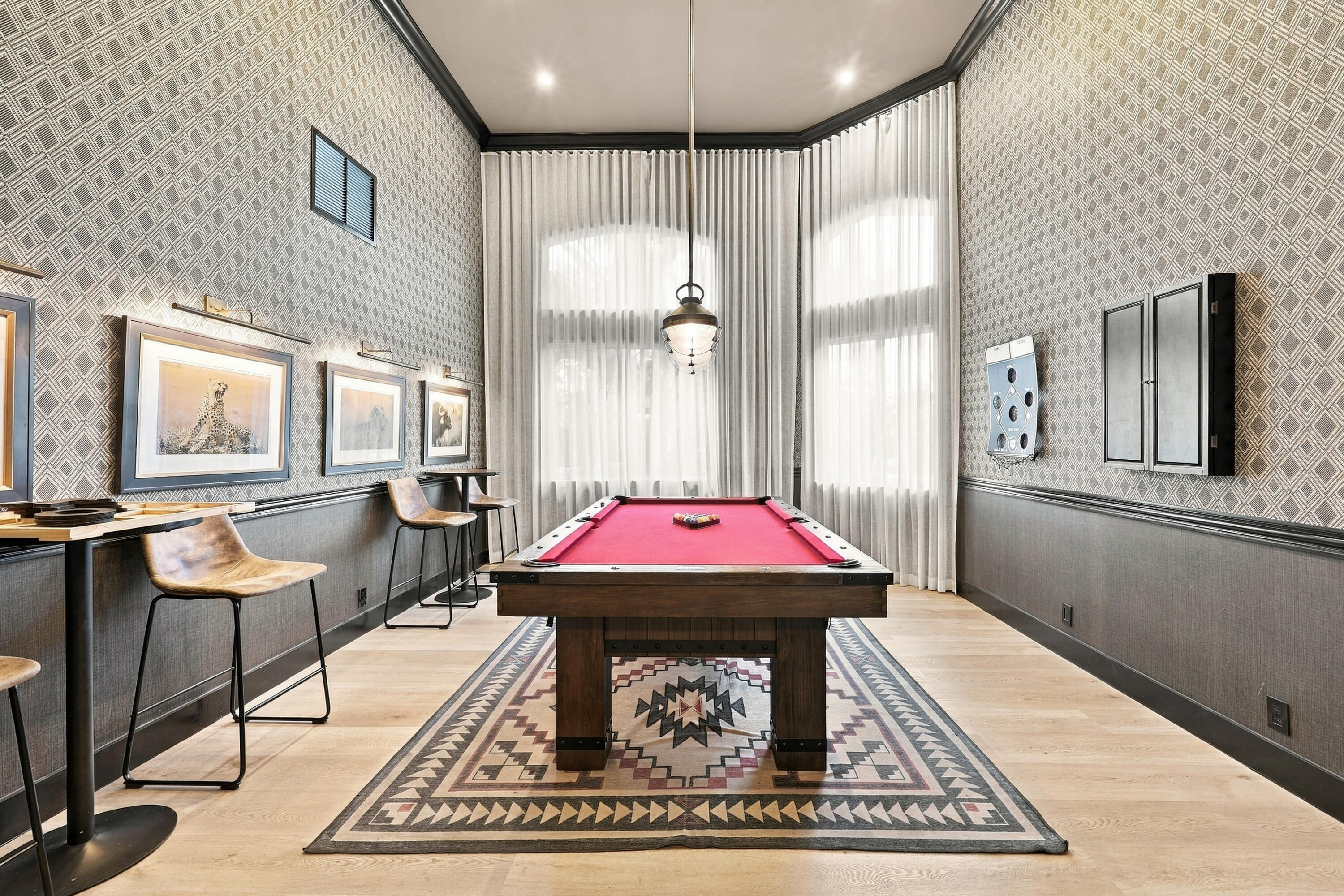 Enjoy a friendly game of pool in the community's dedicated billiards room, featuring a full-size pool table, stylish finishes, and an inviting recreational atmosphere.