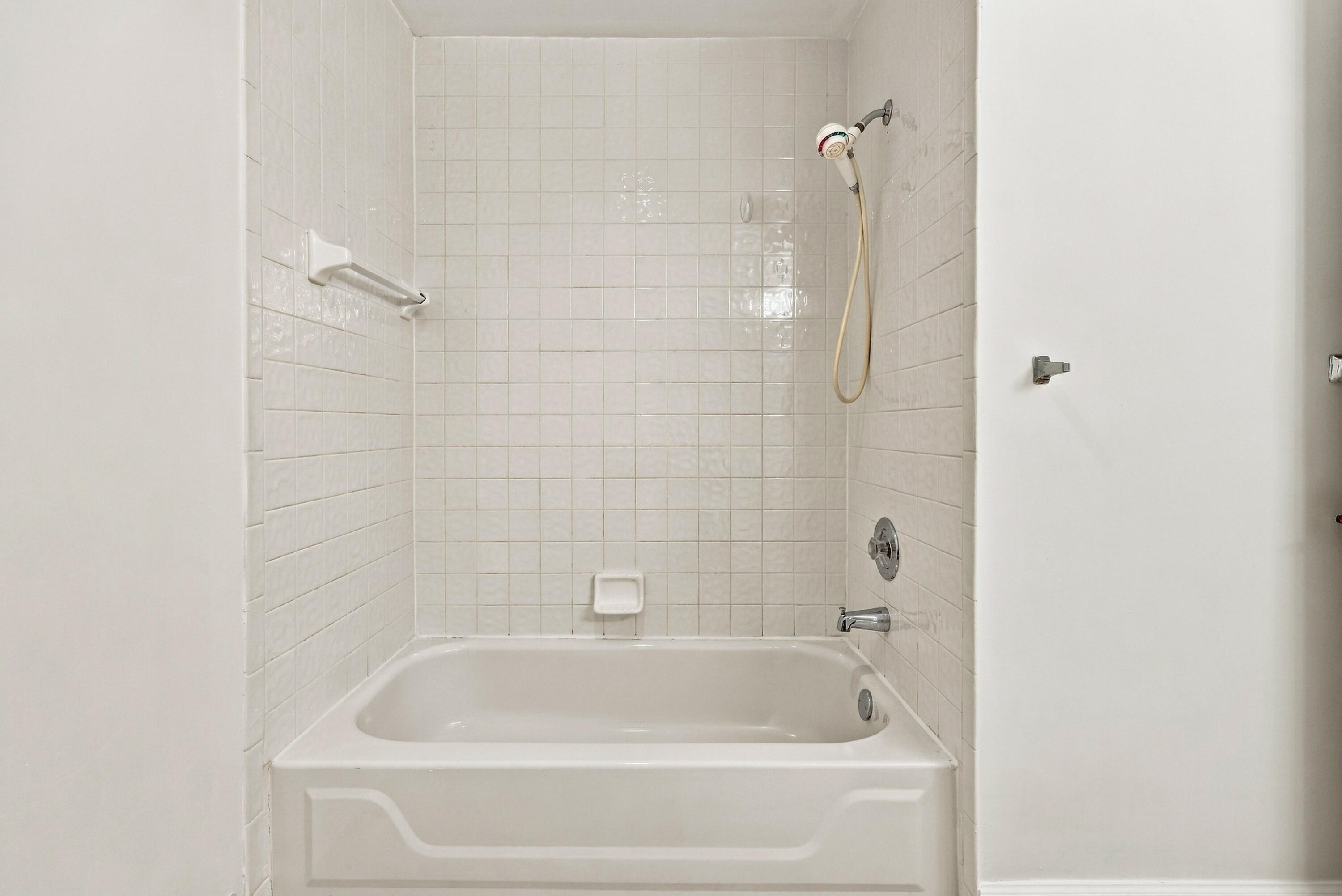 A convenient tub and shower combination with neutral tile surrounds provides comfort and functionality in this second-floor bathroom, ideally situated near the guest bedrooms.