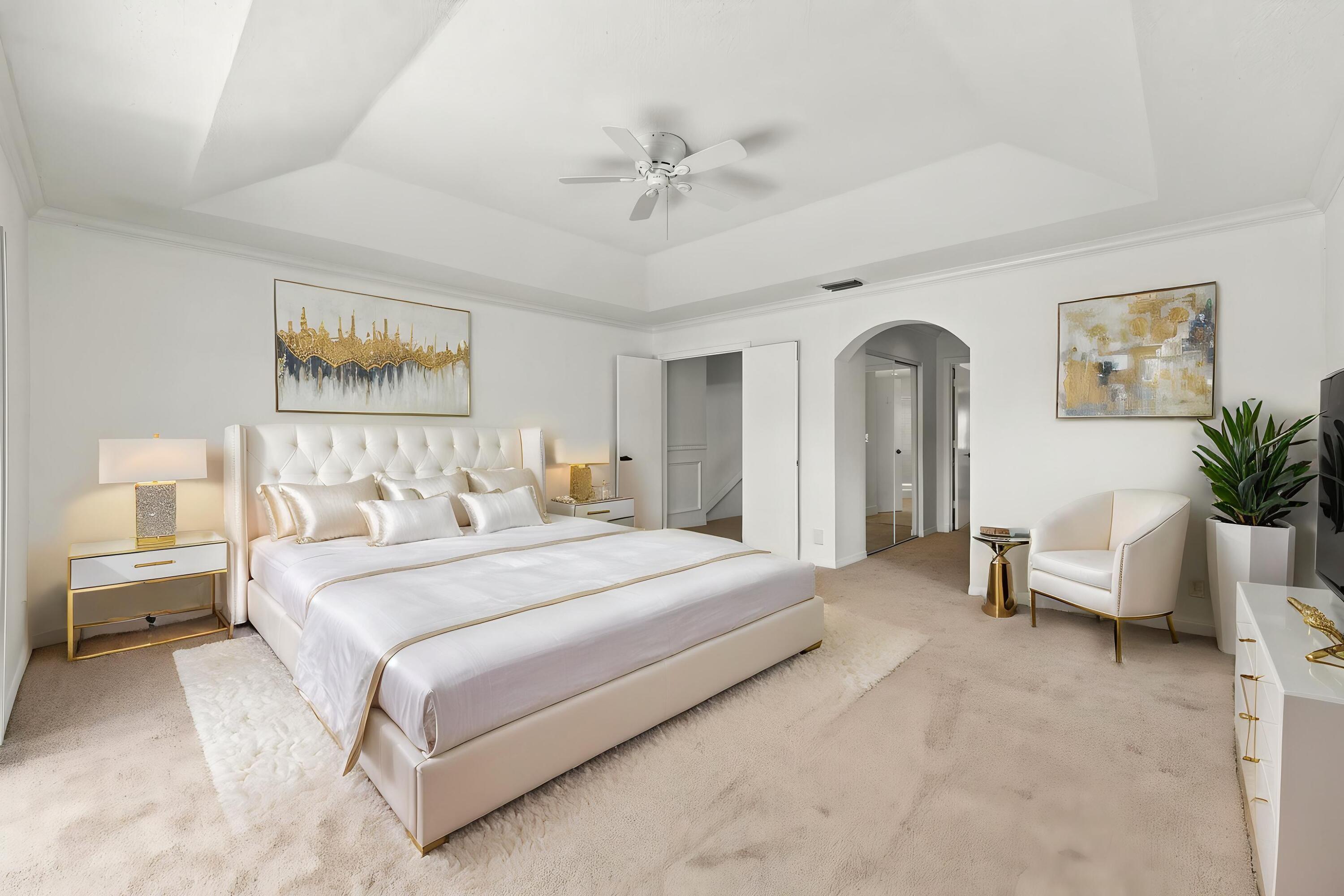 This generously sized primary suite offers an elegant tray ceiling, plush carpeting, and an expansive layout with plenty of room to create your own personal retreat.
