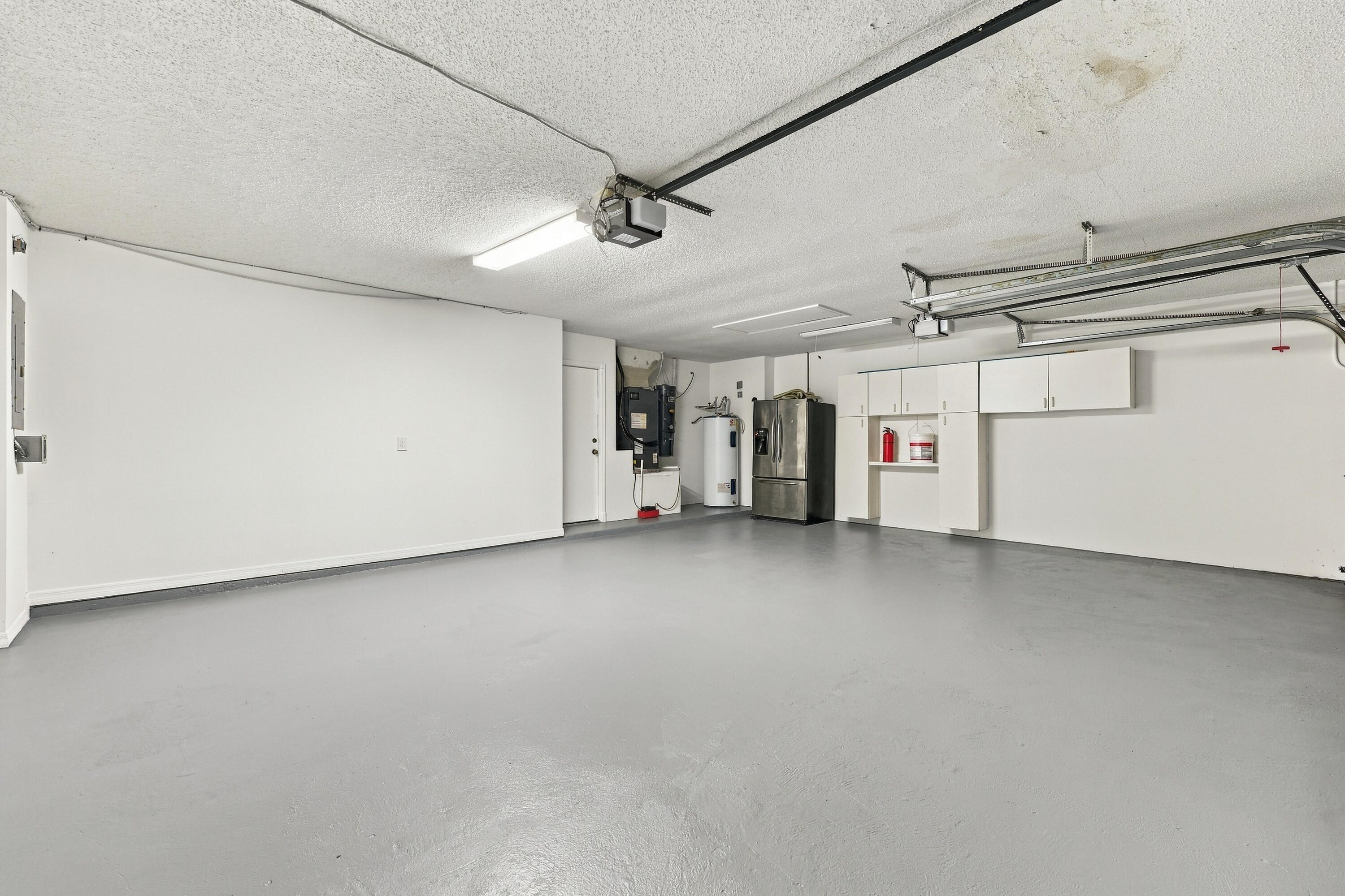 This oversized three-car garage features a finished floor, utility sink, and ample room for vehicles, recreational equipment, additional storage, or a dedicated workshop area.