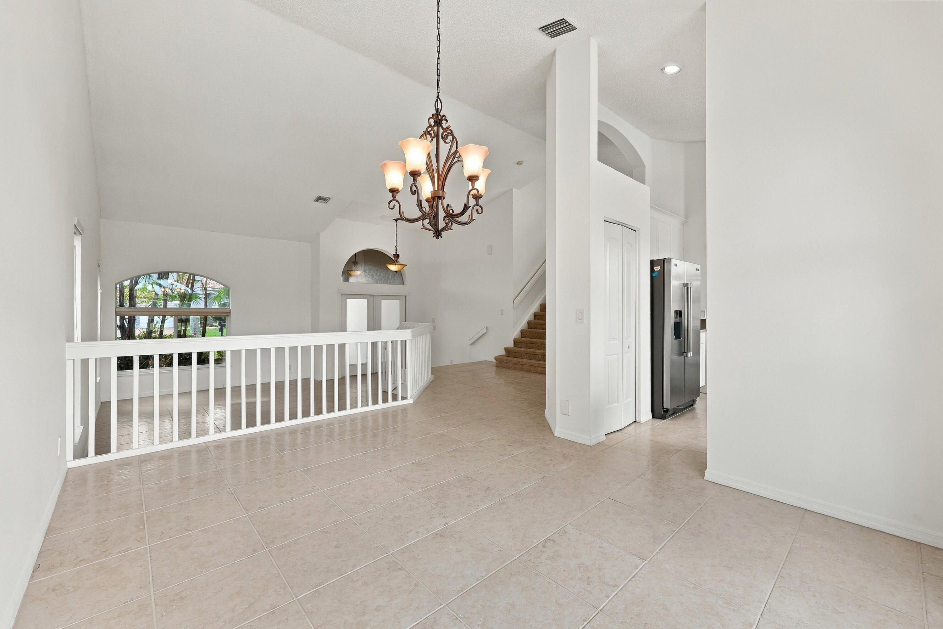 The formal dining room features impressive ceiling heights, decorative lighting, and an open design that adds to the home's spacious character