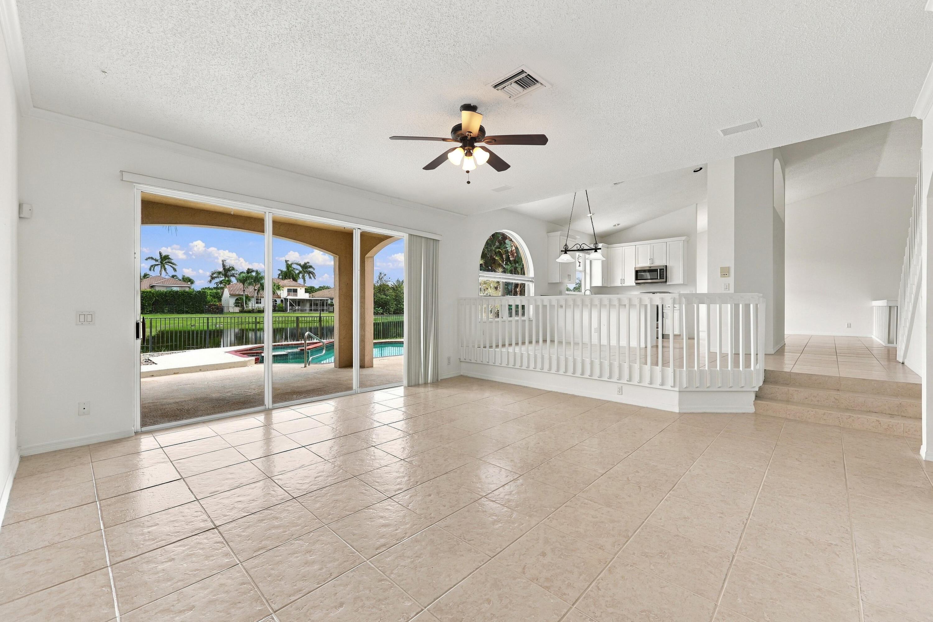 The generous formal living room offers soaring ceilings, an elegant chandelier, and an open design overlooking the home's grand entryway.