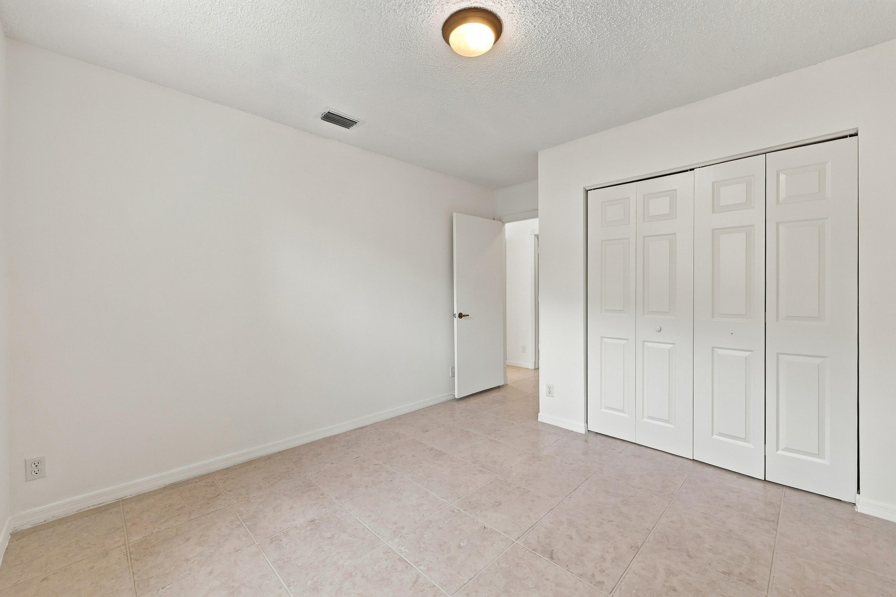A versatile main-level bedroom offering generous closet space, neutral finishes, and a practical layout ideal for guests or a home office.