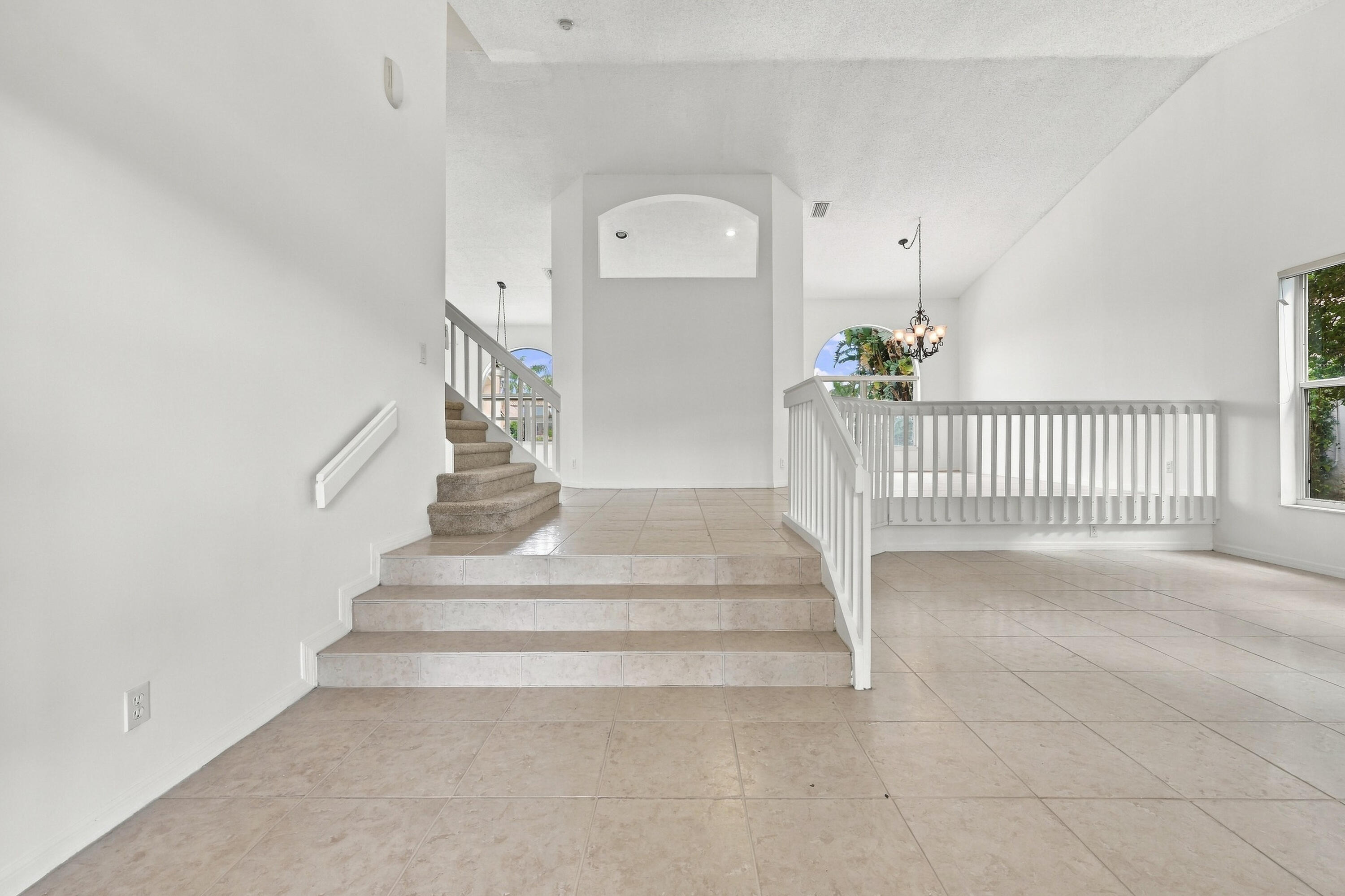 An elegant staircase with white railings complements the home's spacious, multi-level design, creating an inviting transition between living spaces. An elegant staircase with white railings complements the home's spacious, multi-level design, creating an inviting transition between living spaces.
