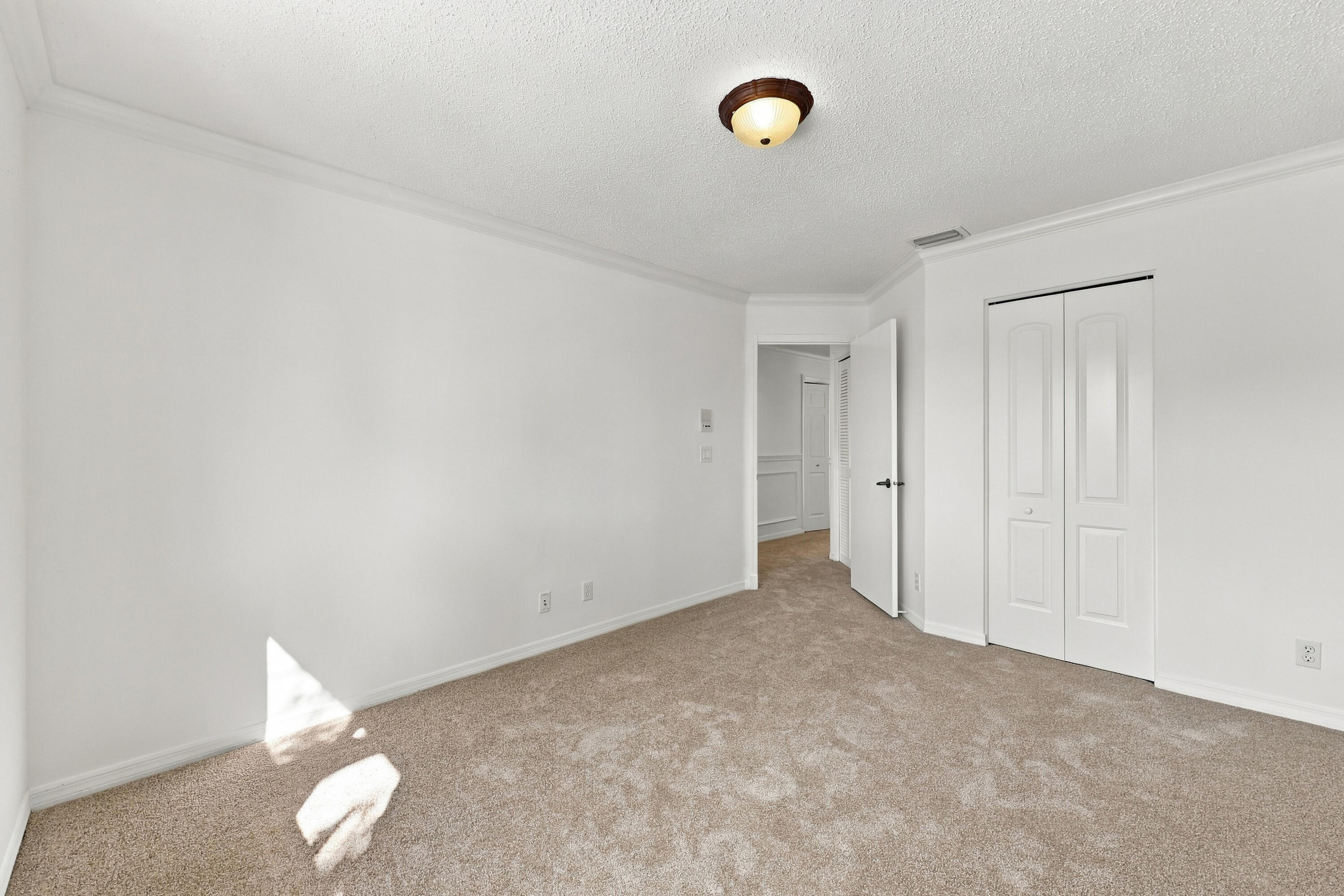 Generous proportions, soft carpeting, and a spacious closet make this bedroom ideal for guests, family members, or a home office.