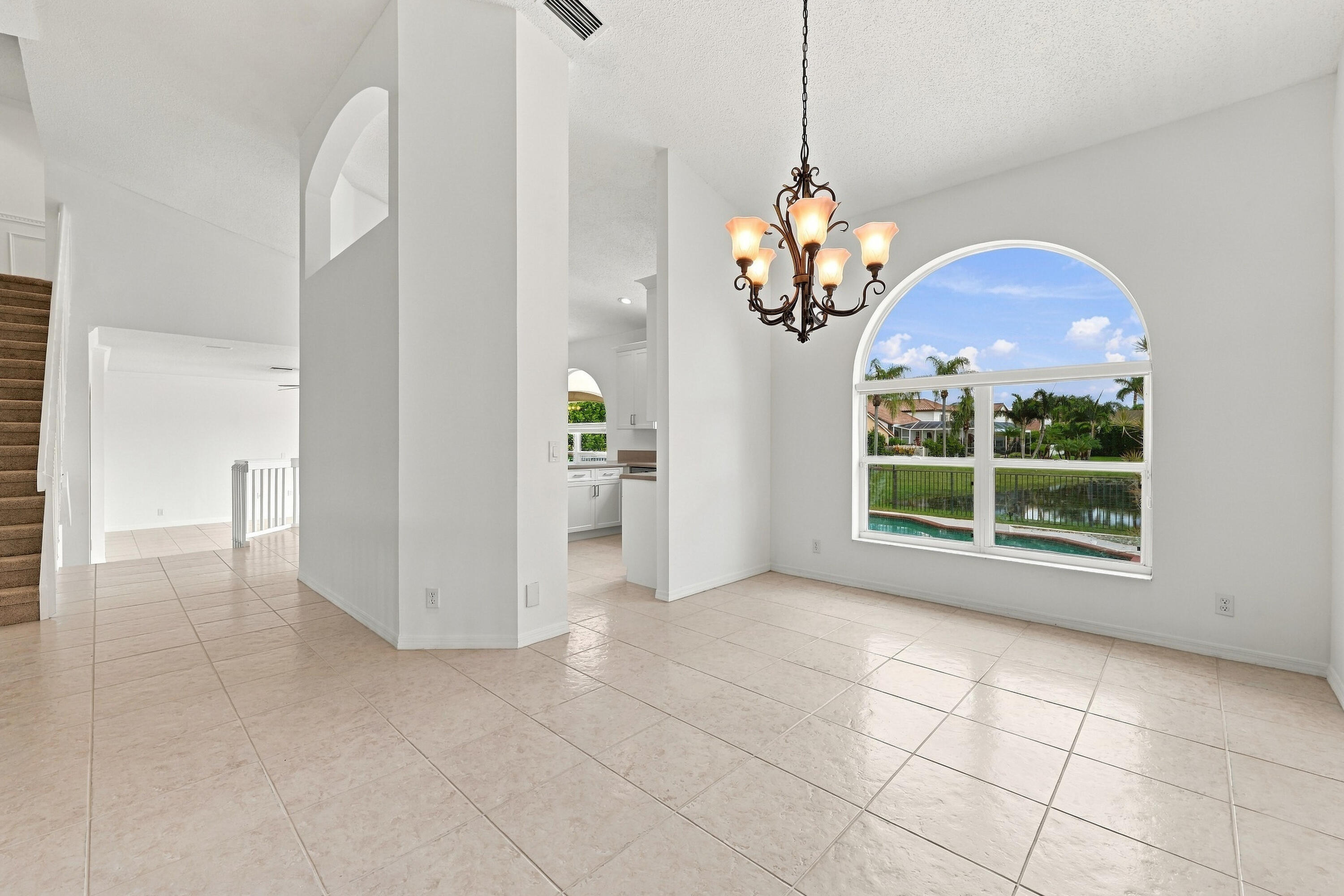 An elegant chandelier, soaring ceilings, and an open connection to the adjacent living areas create a wonderful setting for entertaining.
