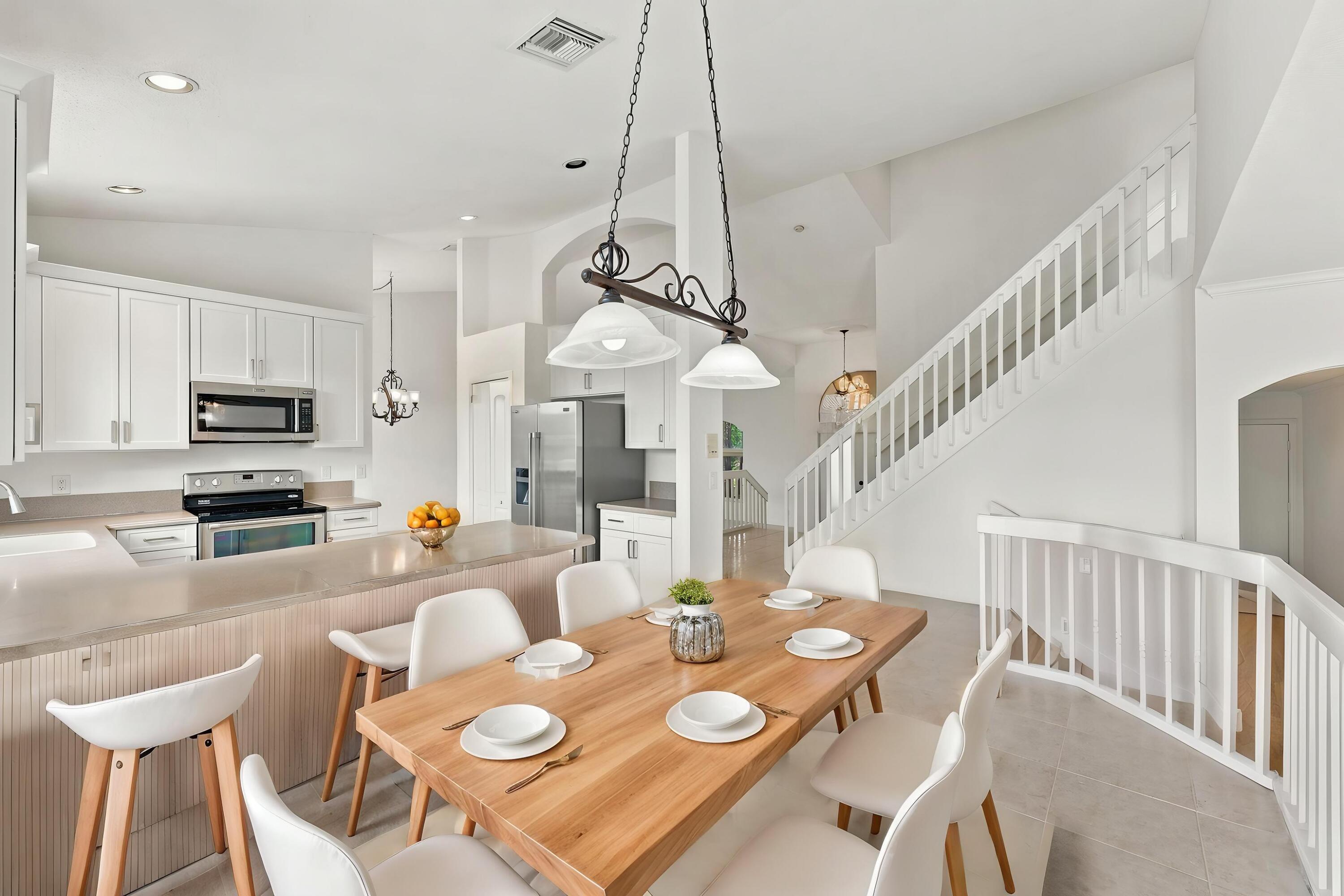 An inviting kitchen and breakfast area featuring white cabinetry, generous counter space, and an open design that connects seamlessly to the surrounding living areas.