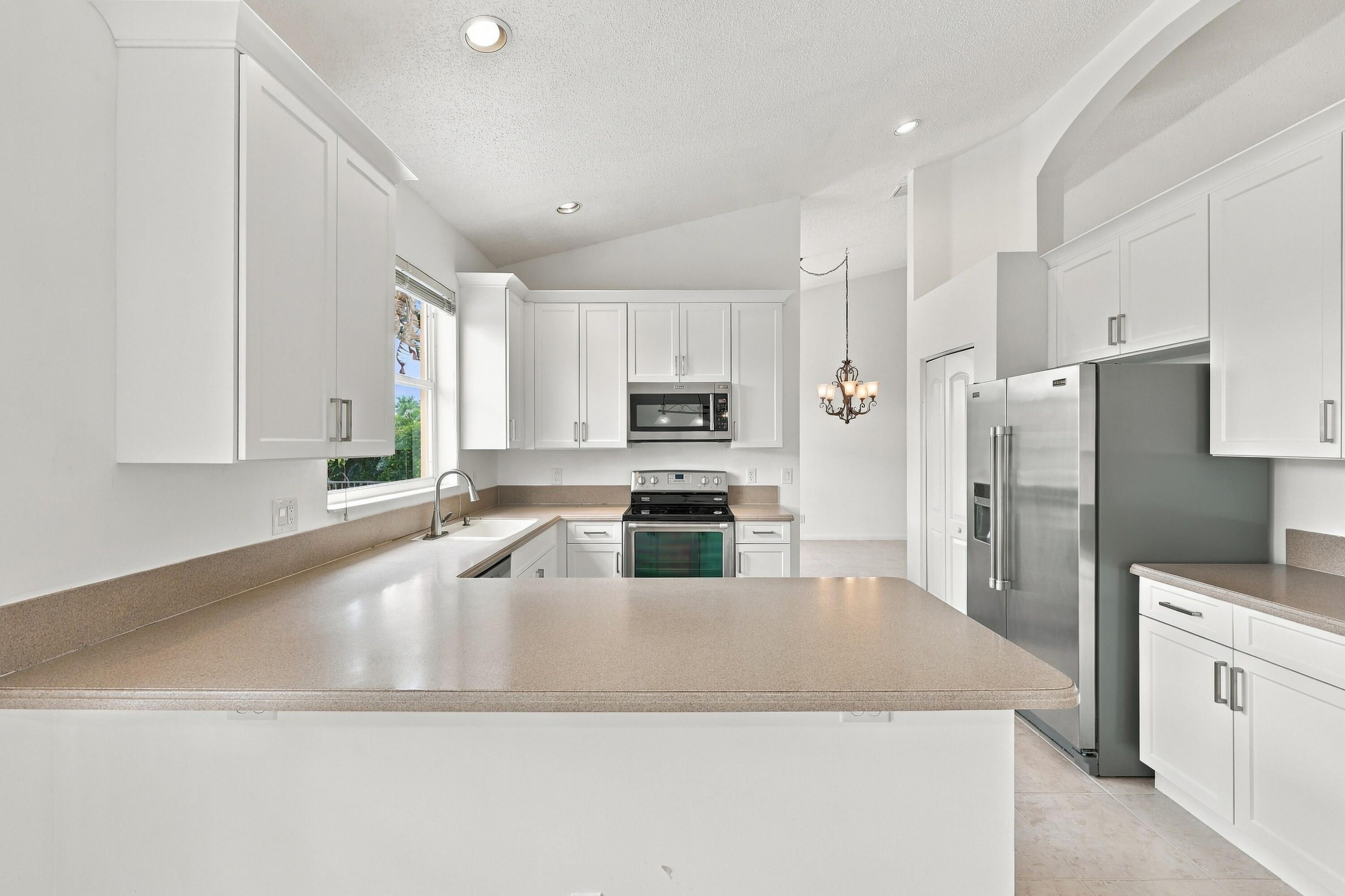 Generous countertop space, abundant cabinetry, and a practical U-shaped layout make this kitchen ideal for meal preparation, entertaining, and everyday living.