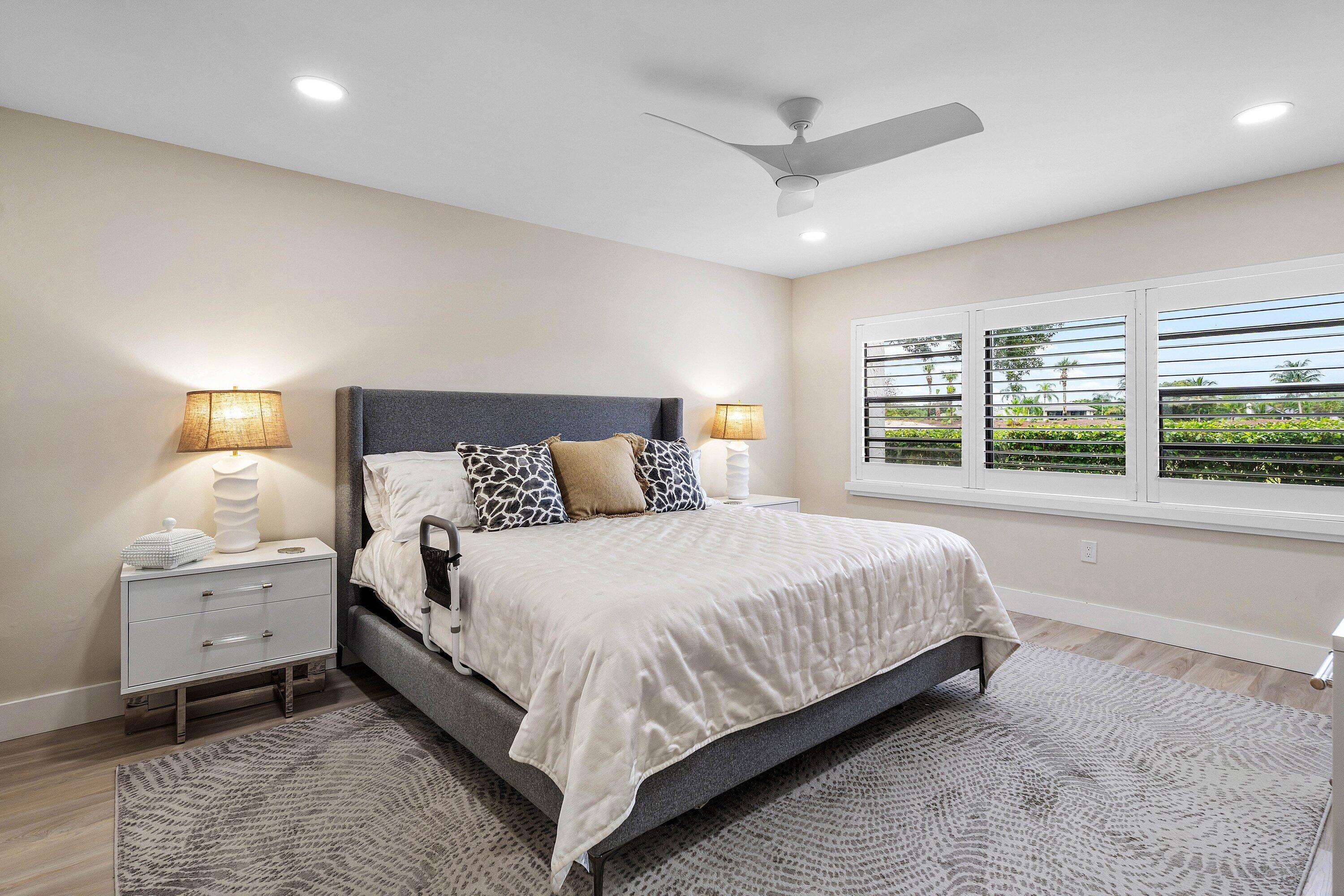 Neutral-toned walls, recessed lighting, modern ceiling fan, wood-finish flooring, and white plantation shutters