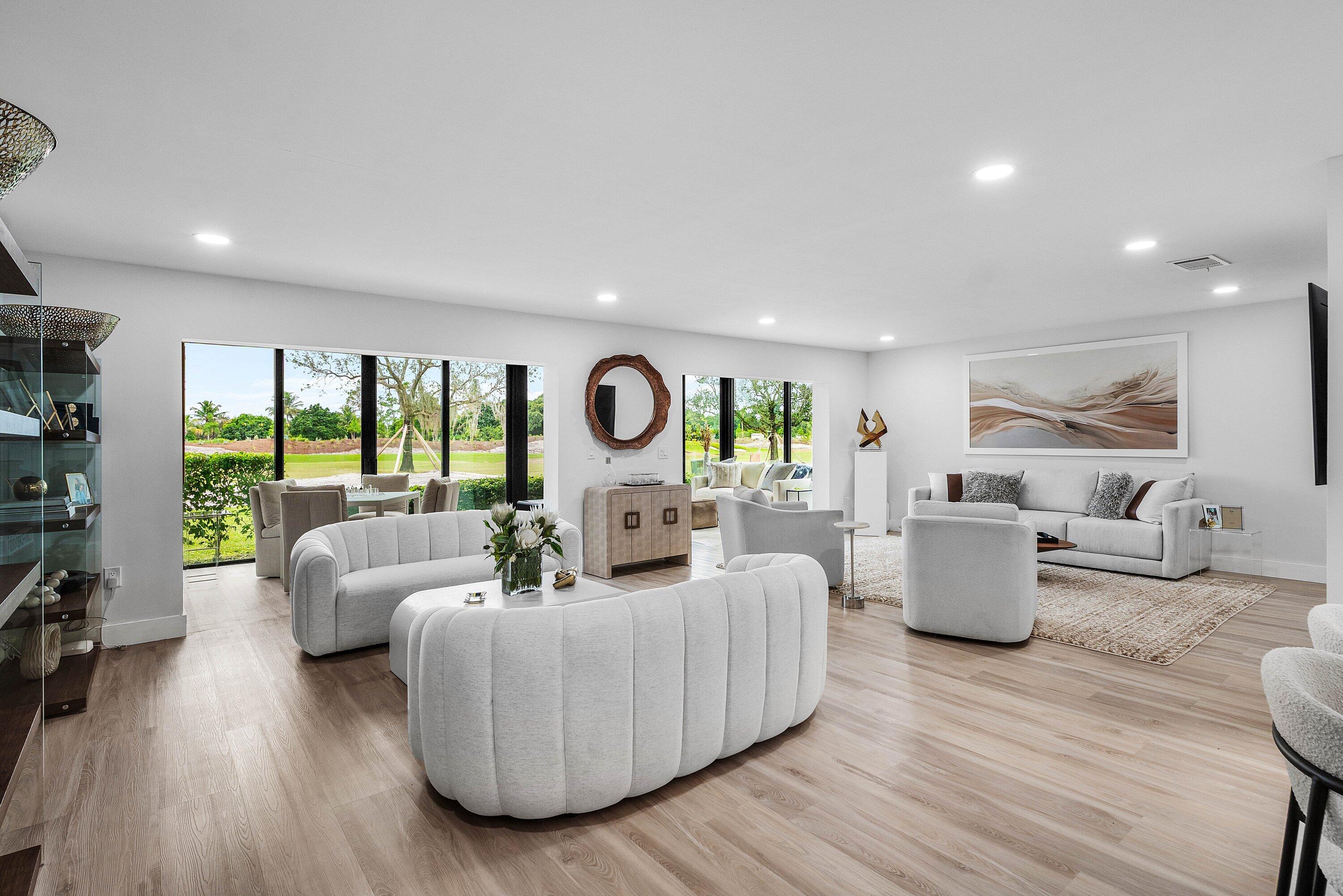 Open-concept living space featuring wood-finish flooring, recessed lighting, and expansive glass sliding doors