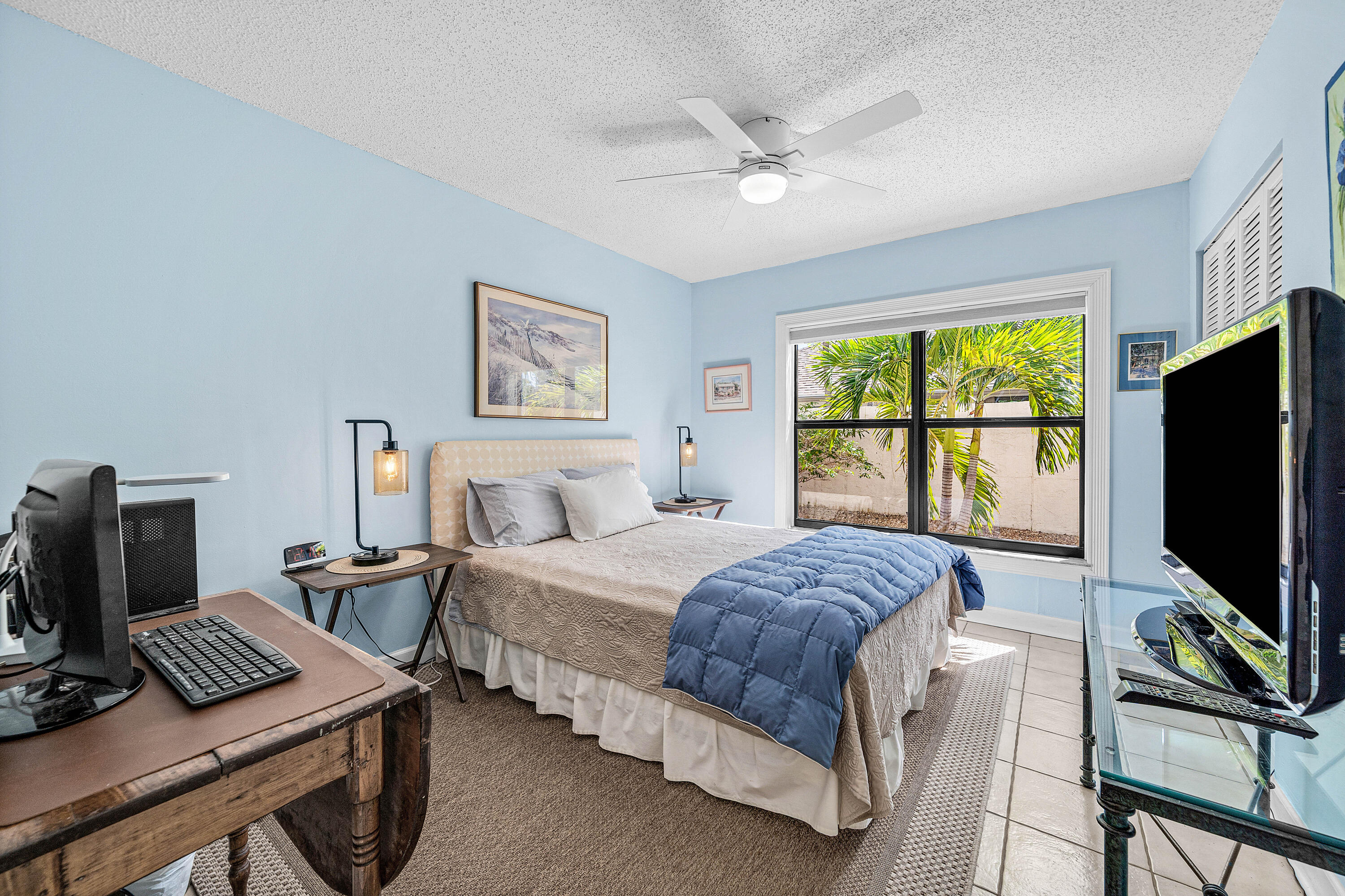 Room featuring tile flooring, a dual-pane window with black framing, and an integrated ceiling fan with light fixture