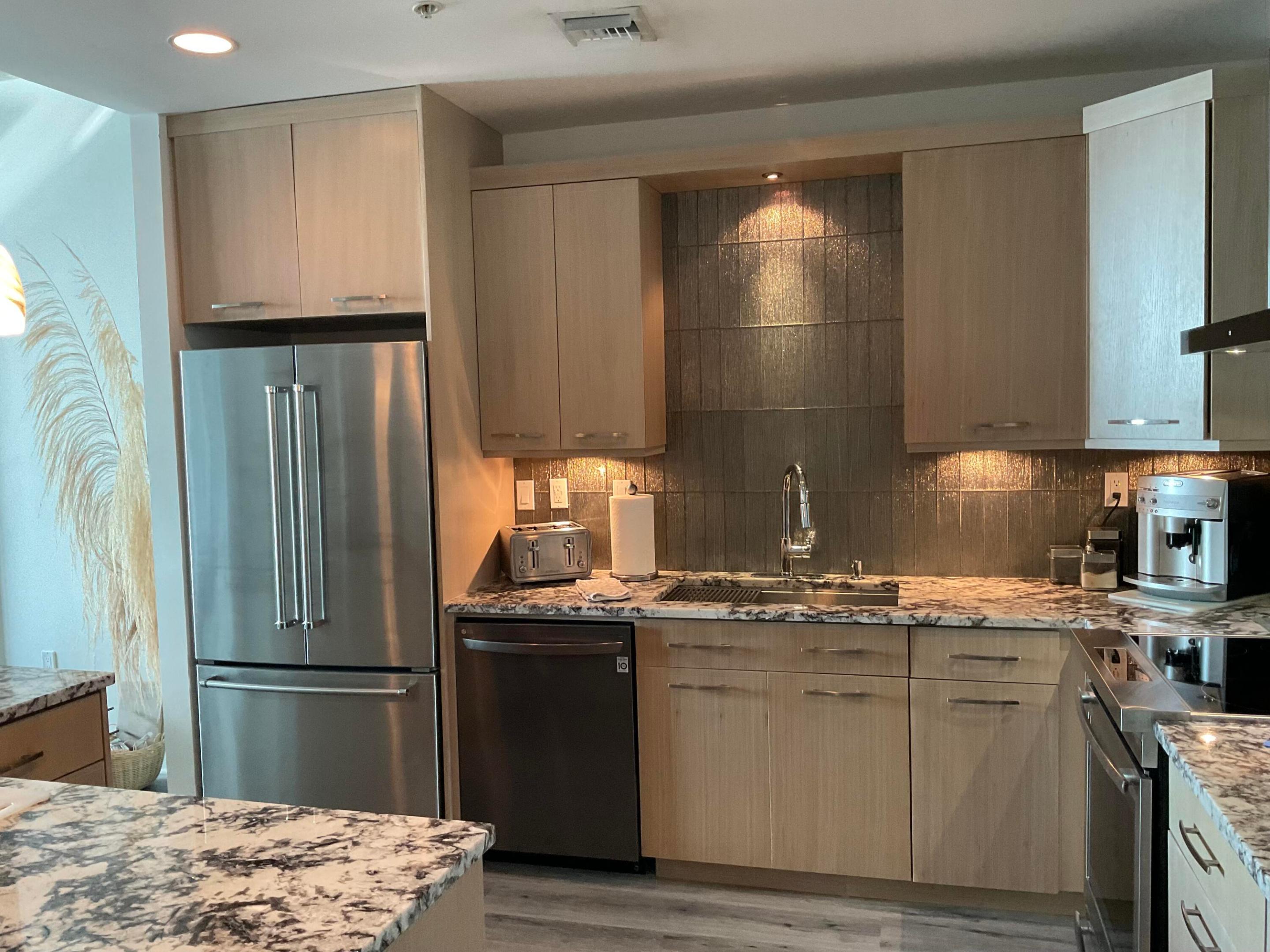 Kitchen with Custom marble counter tops and glass backsplash fully equipped with pans, dishes, cutlery, and small appliances. Kitchen with Custom marble counter tops and glass backsplash fully equipped with pans, dishes, cutlery, and small appliances.