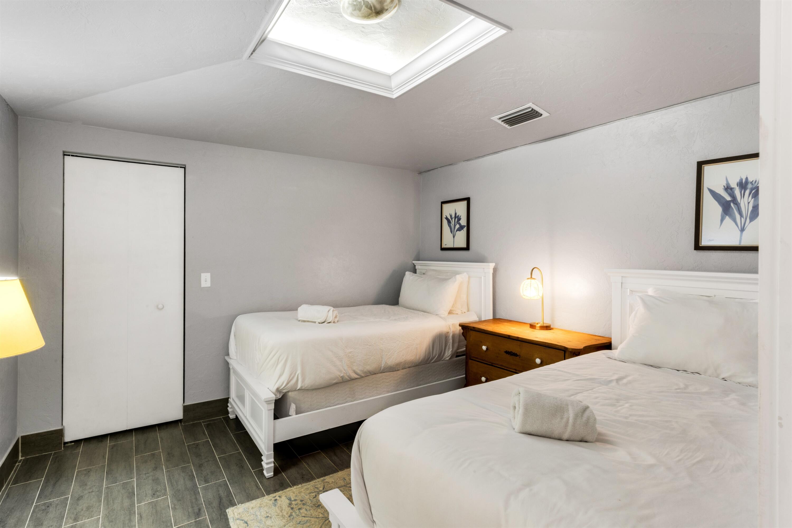 Room featuring a rectangular skylight, wood-finish flooring, and a floor-to-ceiling closet with a white panel door
