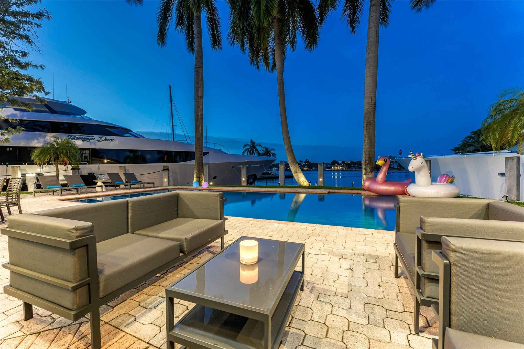Outdoor waterfront Point Lot with pool area with outdoor dining, lounge chairs, BBQ & siting area.