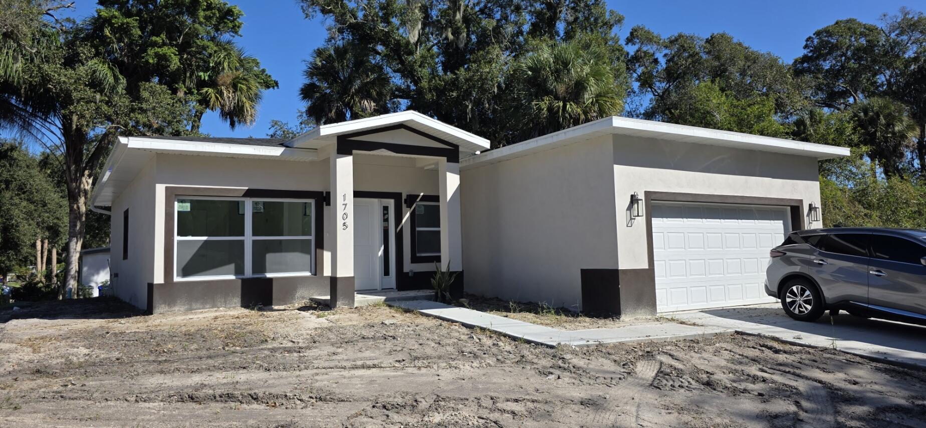 Single-story residence featuring a stucco exterior, covered entryway, attached garage, and multi-pane windows Single-story residence featuring a stucco exterior, covered entryway, attached garage, and multi-pane windows