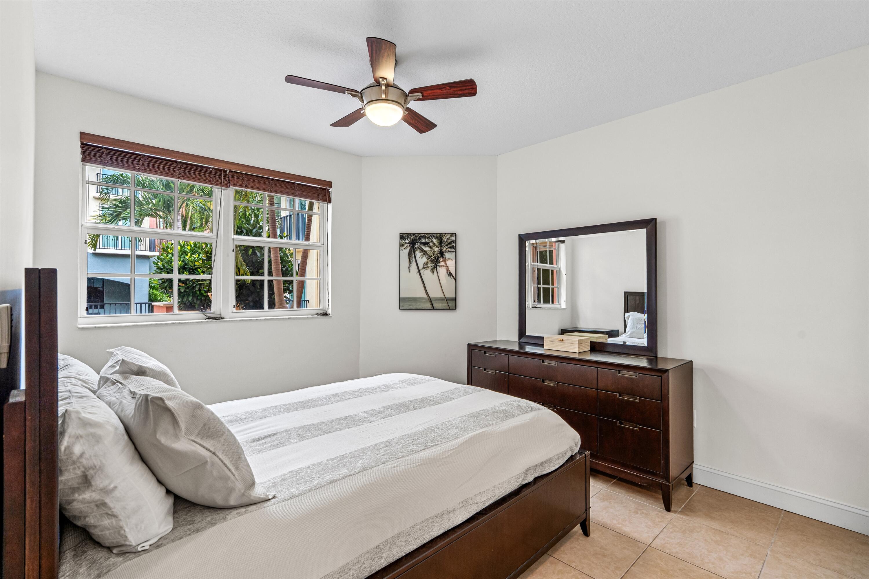 Multi-pane windows with integrated blinds, tile flooring, and a central ceiling fan with integrated lighting