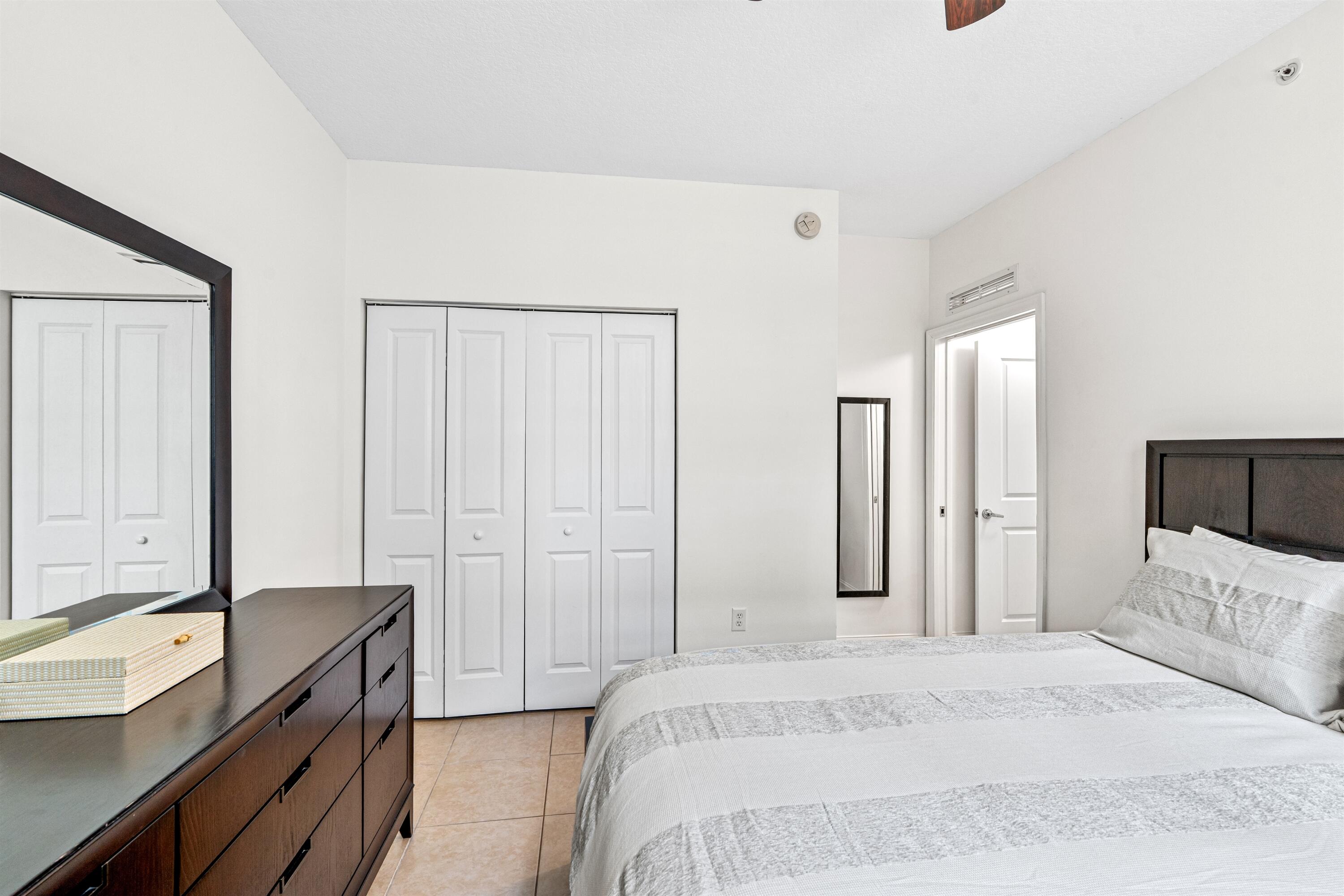 Neutral-toned interior featuring tiled flooring, a built-in bi-fold closet, and a ceiling fan