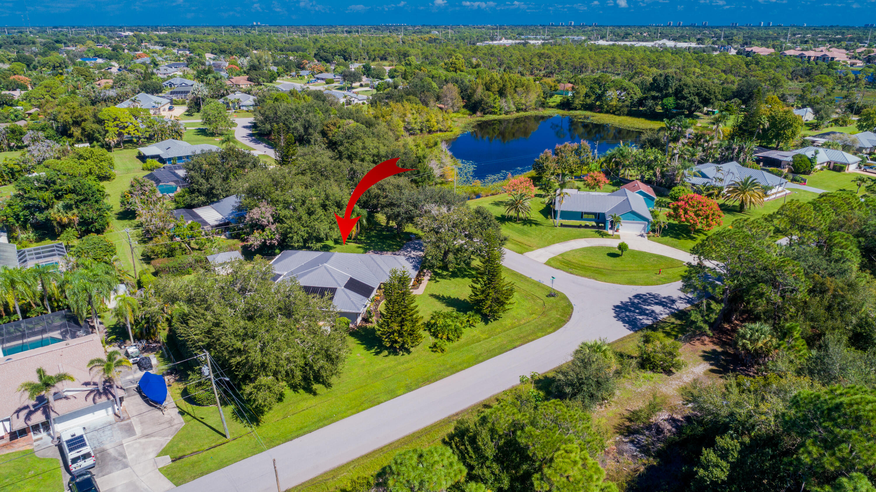 A bird's-eye view of this beautifully landscaped .49-acre property in Sandpiper Bay! Enjoy mature trees, a fully fenced yard, a screened pool, and the privacy of a generously sized lot with no HOA.