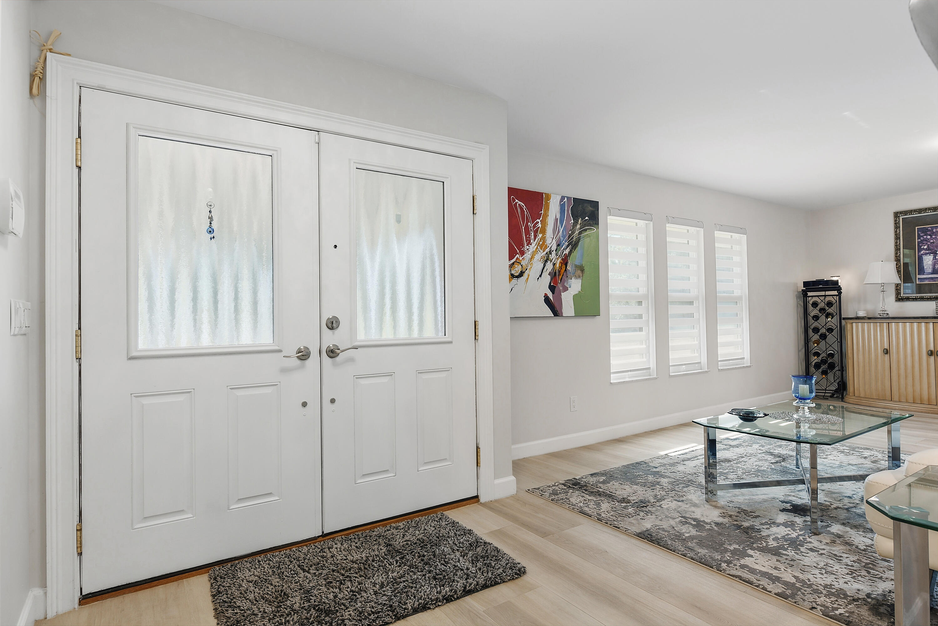 double entry doors with decorative glass panels open to a bright, inviting living room