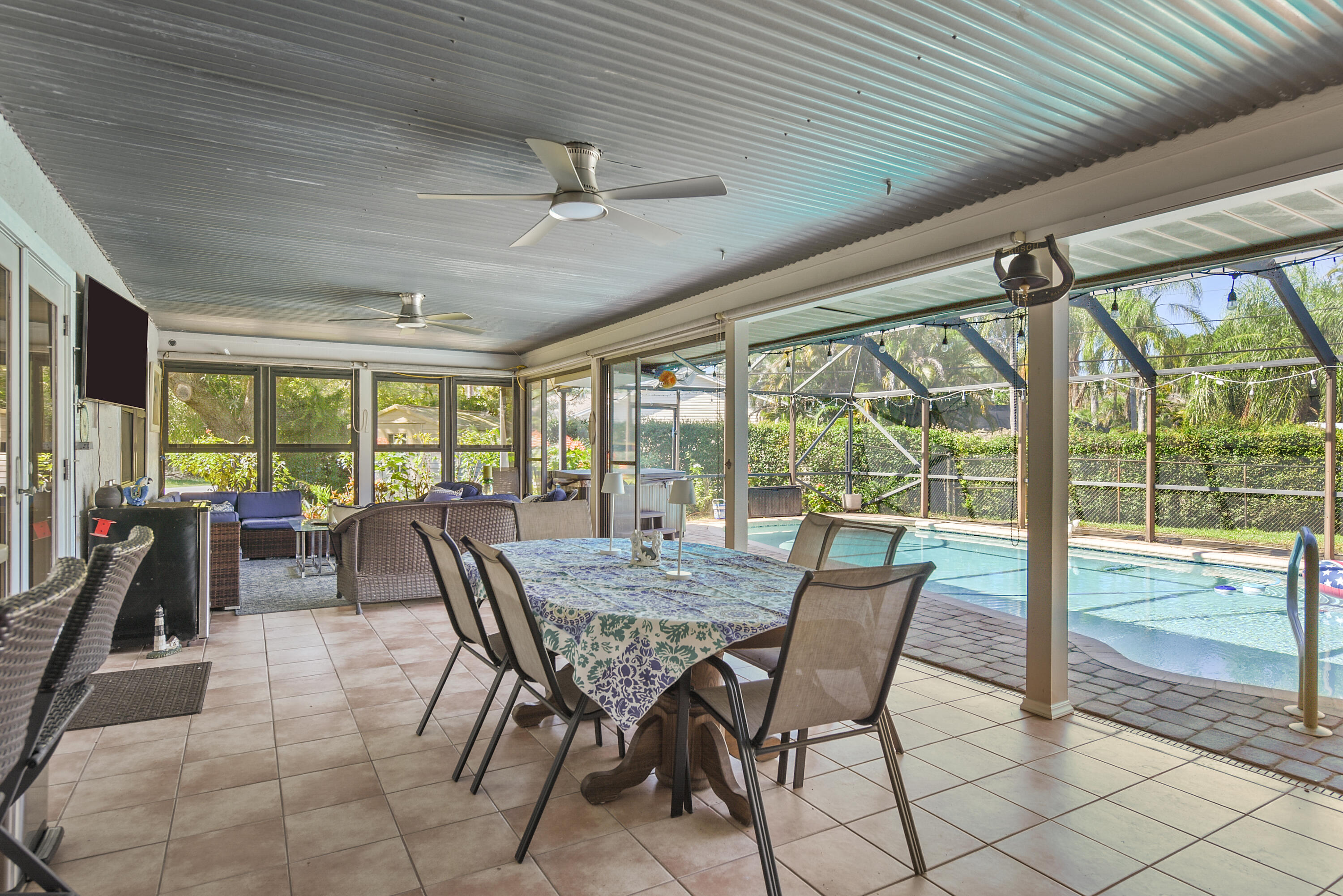 Enjoy the best of indoor-outdoor living! This inviting enclosed lanai features dining and lounging areas, ceiling fans, and beautiful views of the pool. Perfect for entertaining or simply unwinding! Enjoy the best of indoor-outdoor living! This inviting enclosed lanai features dining and lounging areas, ceiling fans, and beautiful views of the pool. Perfect for entertaining or simply unwinding!