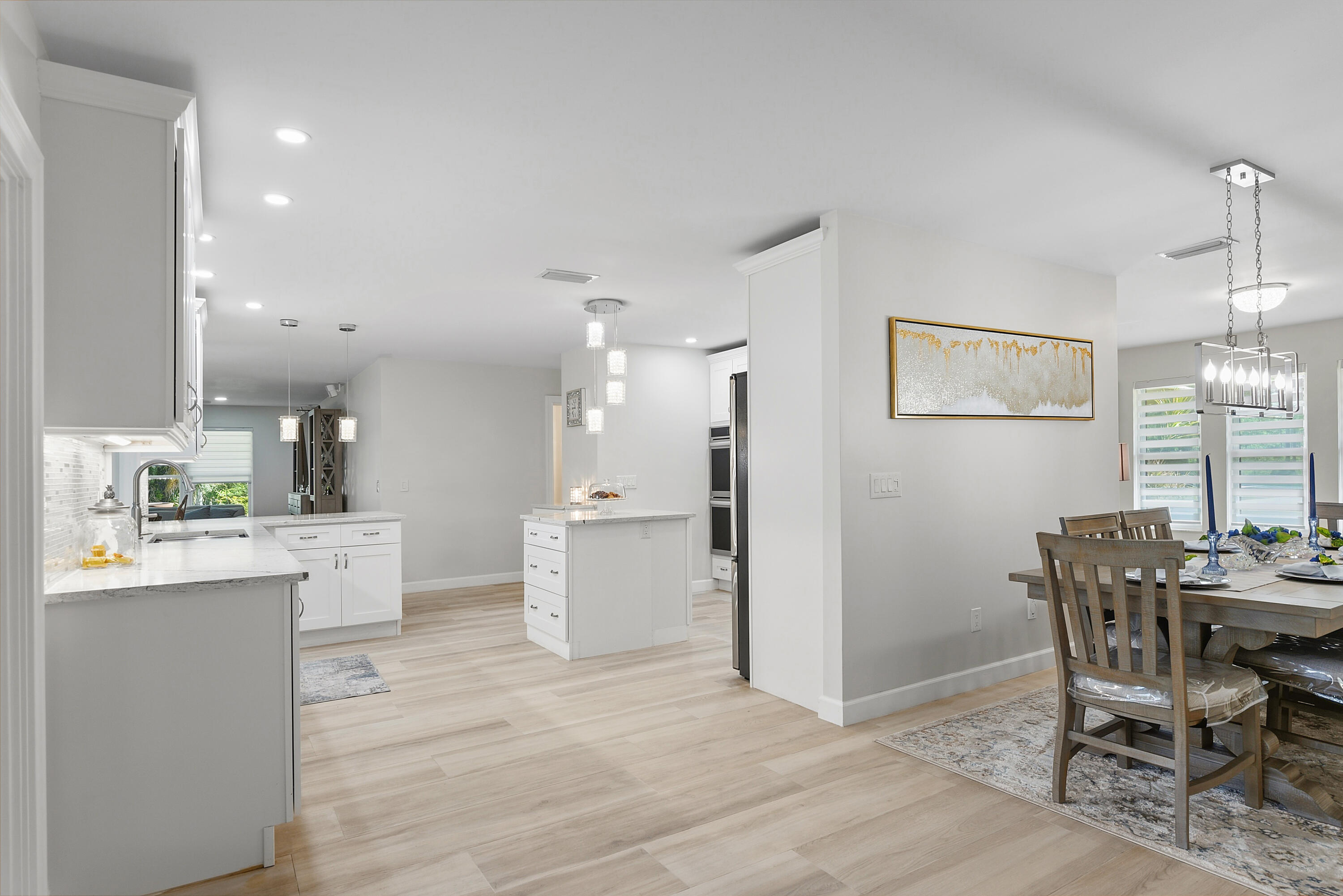 Freshly painted interiors, updated lighting, and beautiful flooring create a bright, modern feel throughout the open kitchen and dining area.