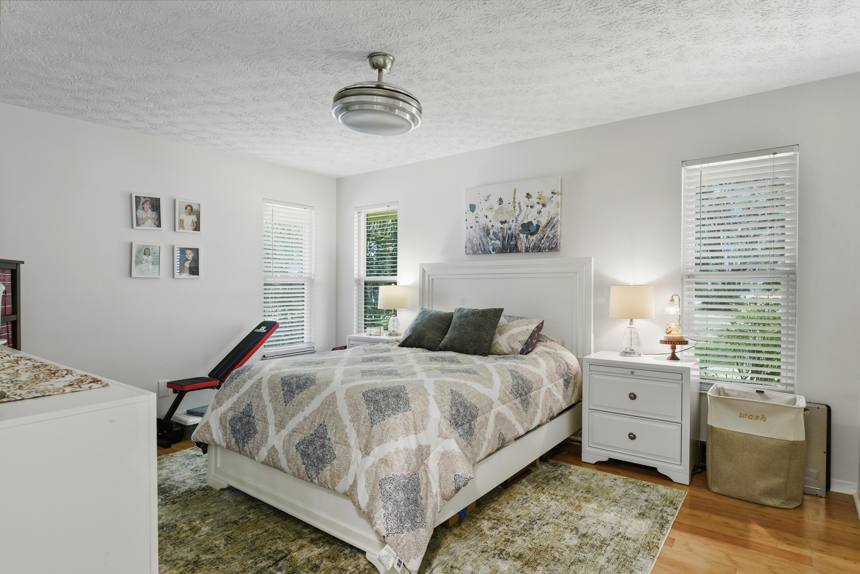 Bedroom 3 offers beautiful flooring, abundant natural light, stylish window treatments, and a new ceiling fan. A welcoming and comfortable retreat!