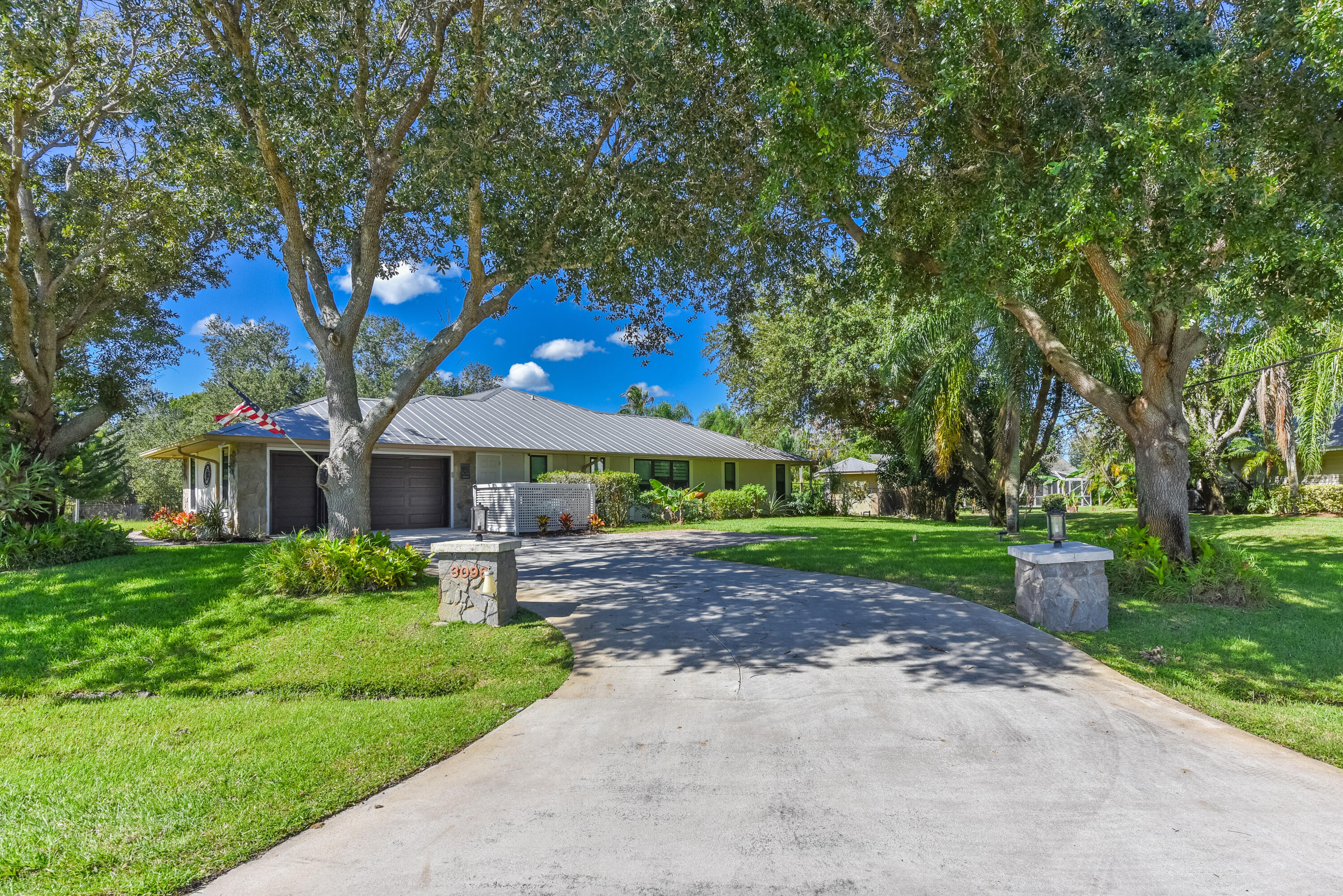 A welcoming driveway framed by majestic shade trees creates an impressive entrance to this .49-acre corner lot. A wonderful sense of privacy and charm in Sandpiper Bay!