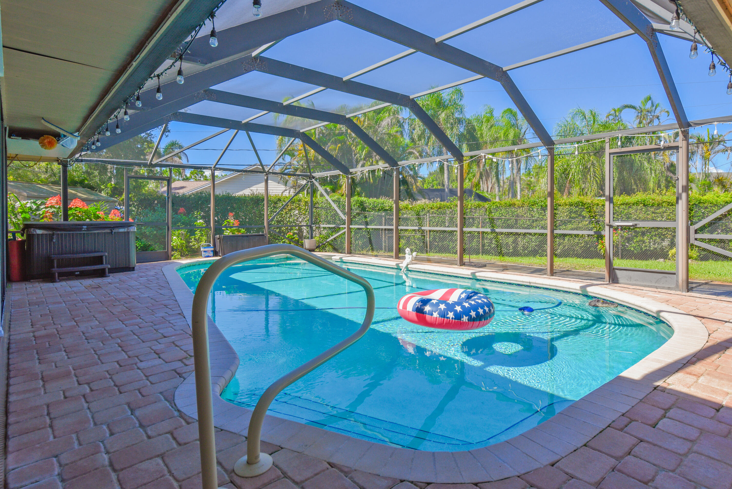 Dive into Florida living! Enjoy the pool, relaxing spa, and screened enclosure surrounded by lush tropical landscaping