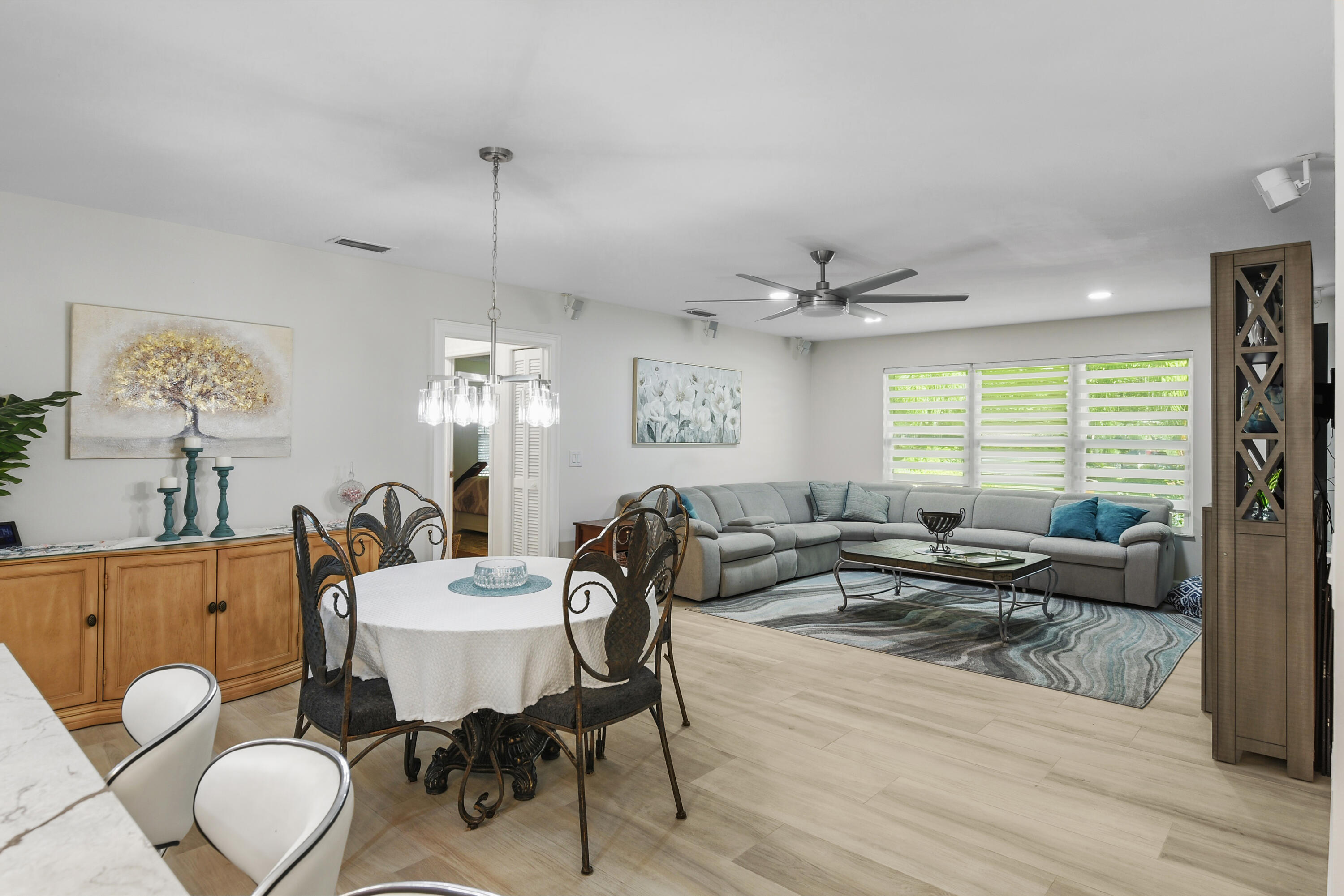 Bright, spacious family room flows seamlessly into the casual dining area and kitchen. Beautiful wide-plank flooring, modern ceiling fan, and stylish window treatments create an inviting space for relaxing and entertaining!