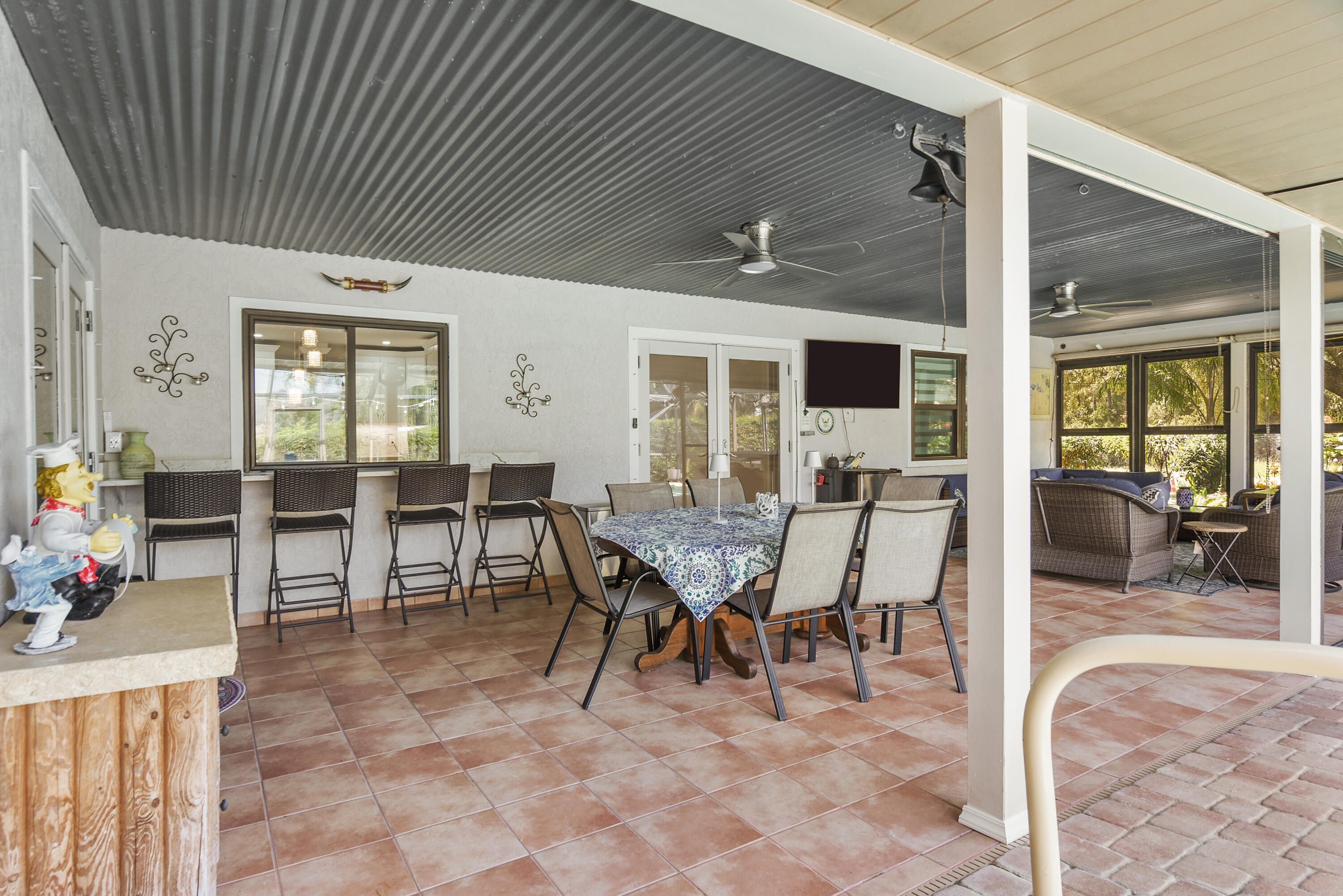An entertainer's delight! This impressive covered lanai offers a dining area, breakfast bar, outdoor TV, and comfortable lounging space overlooking the pool. Perfect for gatherings or quiet afternoons!