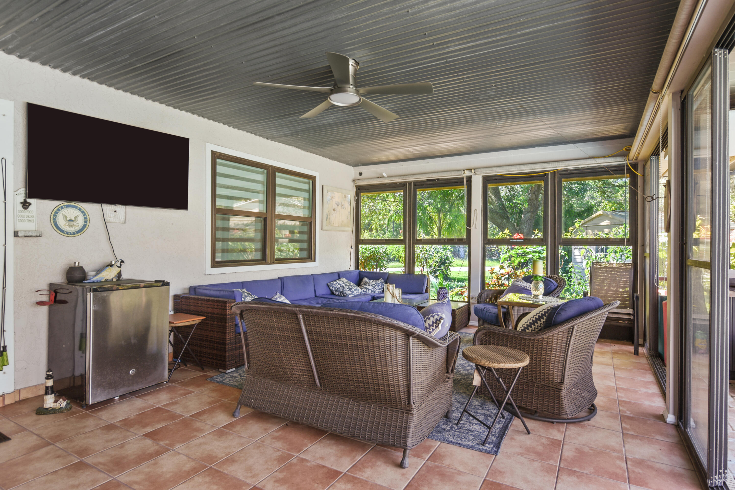 Enjoy year-round outdoor living in this expansive covered lanai, featuring screened enclosures, sliding glass panels, and dedicated dining and lounging areas overlooking the pool. Perfect for entertaining!
