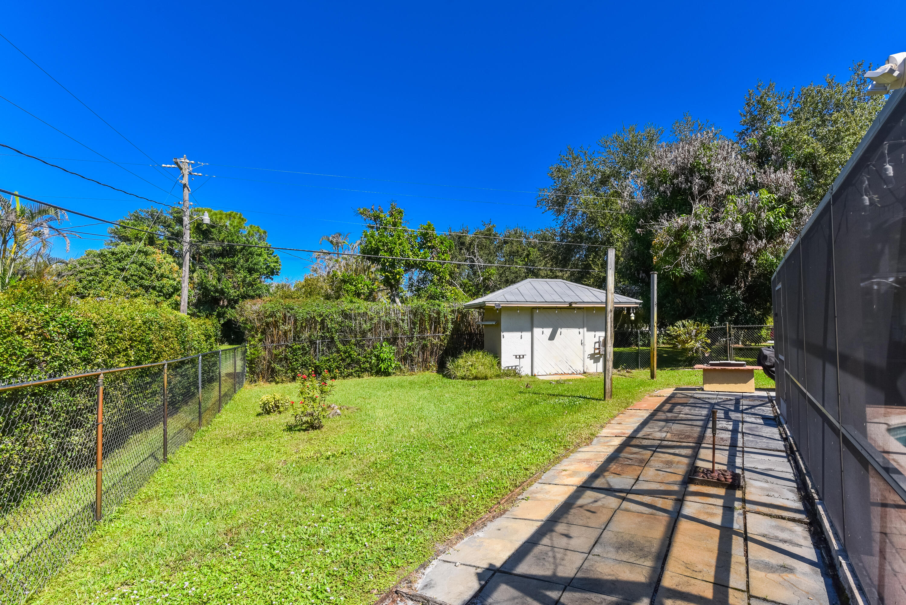 There's more yard beyond the hedges! Enjoy a fully fenced .49-acre property with a generous lawn, mature landscaping, and plenty of room for outdoor activities.