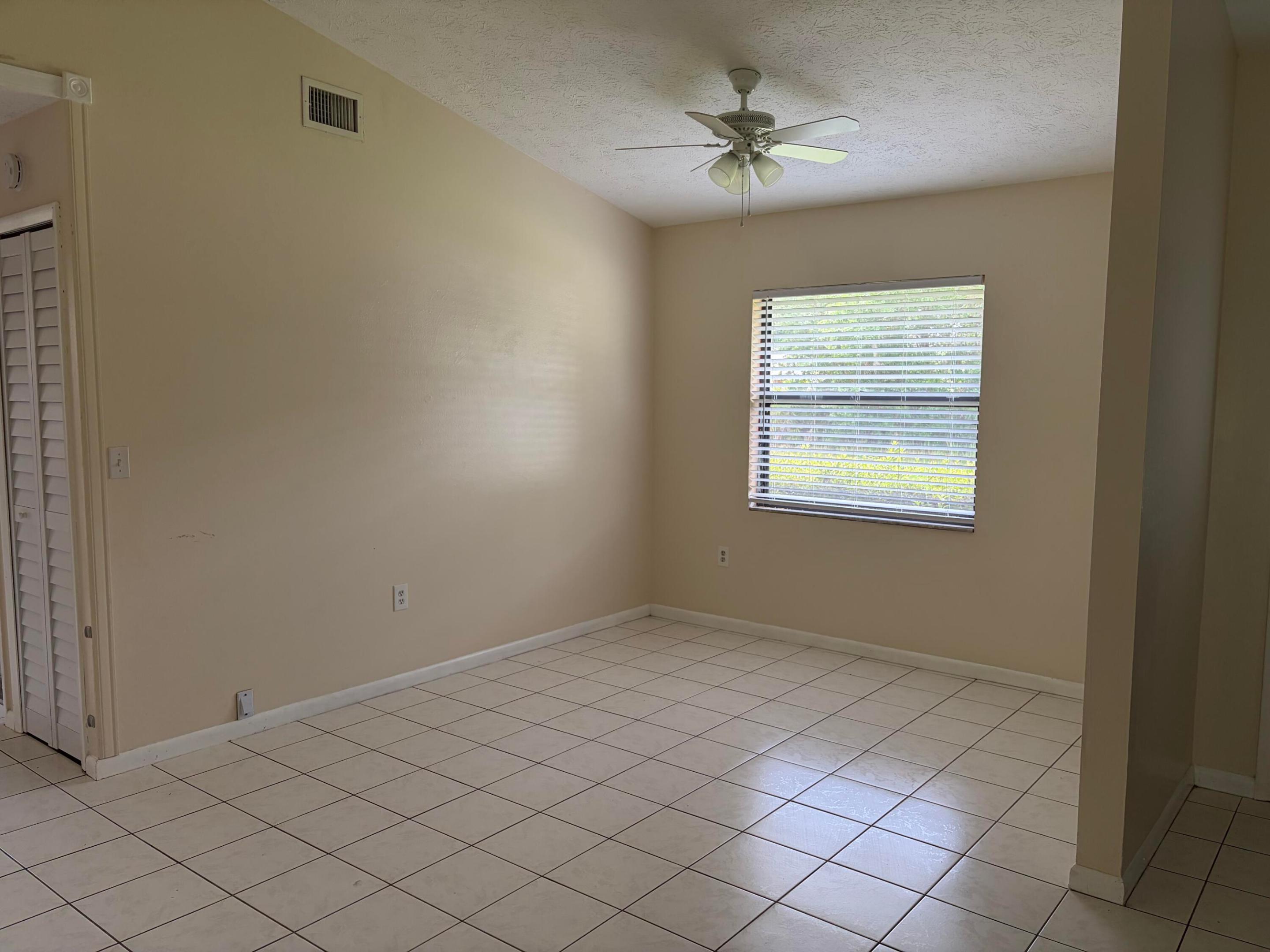 Vaulted ceiling with a white overhead fan, neutral wall finishes, ceramic tile flooring, and horizontal window blinds Vaulted ceiling with a white overhead fan, neutral wall finishes, ceramic tile flooring, and horizontal window blinds
